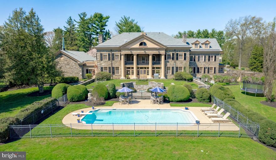 "Windy Hill", an exceptional, classic Georgian-style stone mansion encompassing over 11,000 square feet, was constructed in the late 1920's on one of the highest points in Upper Providence Township, on land that once included the valley now known as Springton Reservoir.  Situated on two verdant acres, Windy Hill is ideally located within close proximity to vibrant downtown Media,  a convenient 12 miles to Philadelphia and rail lines to NYC and DC, and just 20 minutes to Philadelphia International Airport...This meticulously maintained manor home is replete with stately architectural details -  Doric columns, dentilled cornices, Palladian window over the  main entrance portico, 24-pane windows, second floor veranda with sweeping views of the rear grounds, all complimented by thoughtful landscape architecture that incorporates an amazing stone gazebo, two fountains. and stone garden walls, patio and pathways.  Inside, the grandeur of this home unfolds from the elegant center hall, with French doors leading to a gorgeous sunroom with slate floors, coffered ceiling and egress to the rear grounds and pool.  The sunroom can also be accessed via French doors from both the formal dining room and the living room, creating a wonderful, circular flow that connects these generously proportioned, light-filled rooms, and lends itself beautifully to gracious everyday living and large scale entertaining. Both the formal dining room and living room have wood burning fireplaces, as does the family room, which also features a wall of built-in bookcases and egress to the exterior.  The kitchen and adjacent butler pantry include a commercial gas range with two ovens, a commercial Miele dishwasher, lots of cabinet storage, along with a large walk-in pantry.  This quadrant of the home also includes a cozy breakfast room with a powder room (just off the kitchen) and a 13' x 9' mudroom, with egress to the stone-walled kitchen garden area. There is also a  15' x 11' home office with a charming Dutch door dedicated egress. Rounding out the main level is the chapel wing, which features a 45' x 29' great room with slate floors and cathedral ceiling.  This highly flexible mega space has unlimited usages - exercise or artist's studio, music room, recreation room, or potential  conversion to garage space for the car enthusiast..... Access the second level via the curved, balconied staircase that leads to the lovely master suite with fireplace, dressing room with built-ins and egress to a private rooftop sun spot, updated master bath, and French doors to the spectacular veranda, an amazing venue from which to view and appreciate the rear grounds.  The second level includes three additional generously-sized bedrooms, all with en suite baths, one featuring a fireplace, and one that also accesses the veranda via French doors.  Also, a rear hallway on this level leads to a light-filled three bedroom, one full bath au pair / guest suite with back stair....The third level includes a bright and charming bedroom with arched window and en-suite bath.  The majority of this level is comprised of a 52' x 24'  ballroom with hardwood floors - another amazing and flexible grand space to adapt to your creative endeavors!  There are two adjacent game rooms - one with lots of built in shelving - and also a walk-in cedar closet!... For the last thirty years, this incredible home has been lovingly cared for and diligently maintained.   Recent infrastructure improvements include roof replacement/copper gutter installation, transition from septic to public sewer, HVAC replacement, hot water heater replacement, full electrical/wiring update,  whole house generator and new concrete pool lining.  This one of a kind property beckons its next lucky steward and truly must be seen to be fully appreciated.