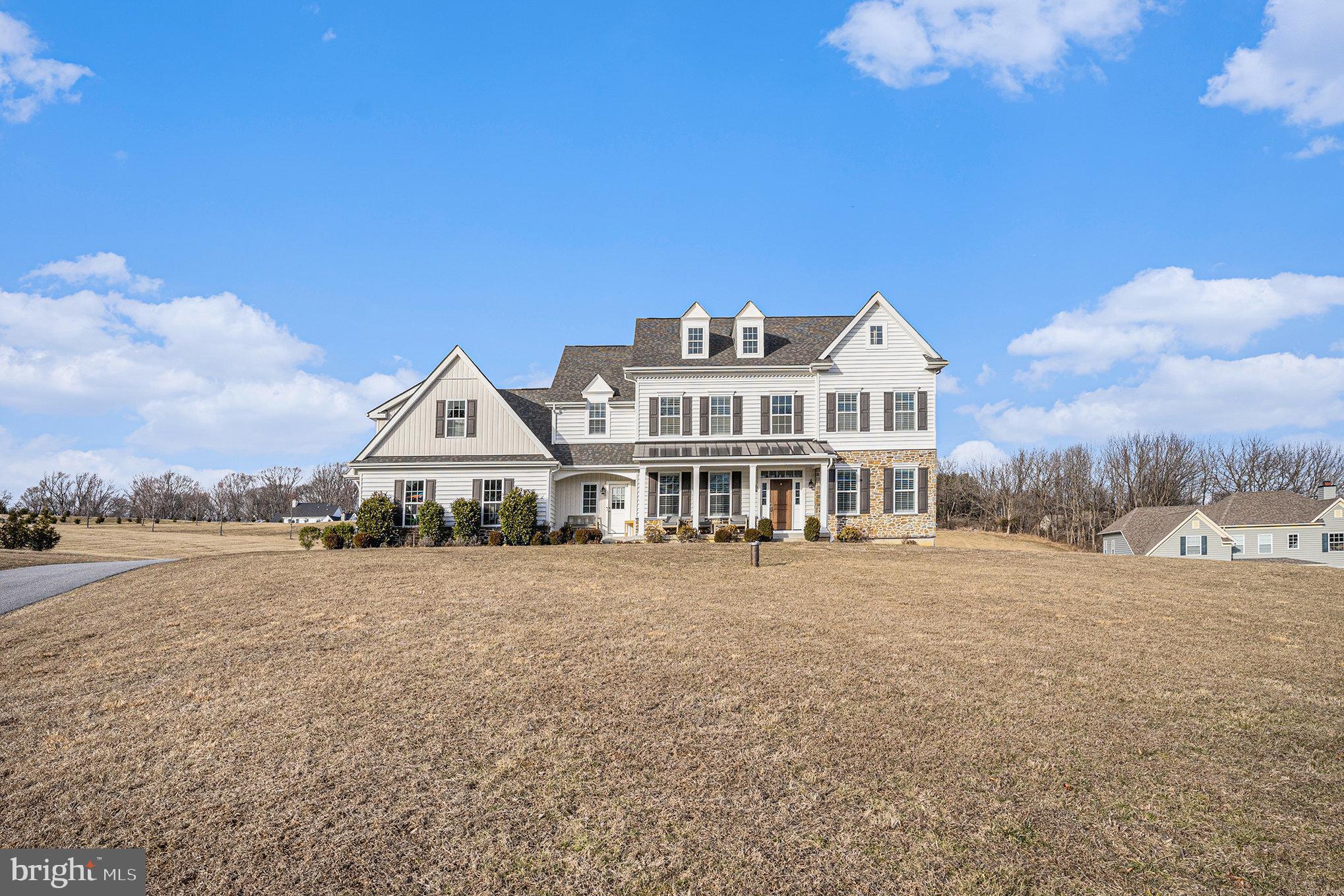 This charming home sits on a private 1.8+ acre lot, offering sweeping views of the surrounding countryside. With its traditional exterior, it draws you in to experience a modern take on the classic farmhouse, effortlessly blending timeless character with today’s most sought-after design elements. Inside, the spacious rooms are highlighted by 9-foot ceilings and expansive windows, creating an open, airy atmosphere throughout.
The heart of this home is its Chef’s Kitchen, complete with stainless steel appliances, quartz countertops, a Butler’s Pantry, and solid wood cabinetry featuring dovetailed joinery, soft-close drawers, and roll-out shelves. A large center island serves as a gathering place, and the kitchen opens into both a sunny Breakfast Room for casual dining and a spacious Family Room, which boasts a fireplace and coffered ceiling. The first floor also includes a private Study, a formal Dining Room, a Powder Room, and a Mudroom.
A beautiful main staircase in the entry foyer leads to the second floor, which houses four generous Bedrooms and three full Bathrooms. The sunlit Owner's Retreat is a serene sanctuary, offering two walk-in closets and an en suite spa bathroom with double vanities, a spacious shower, and a luxurious spa bathtub. Bedroom #2 enjoys its own en-suite bathroom, while Bedrooms #3 and #4 share a hall bath. A convenient 2nd floor laundry room further enhances the home's practicality.
The side-turned 3-Car Garage offers extra storage space and can be accessed from the Mudroom off the kitchen. The Mudroom also provides a private staircase leading to a pre-framed and pre-plumbed space above the garage, which could be finished as an Au Pair Suite, In-Law Suite, 5th Bedroom, or other Bonus Room.
