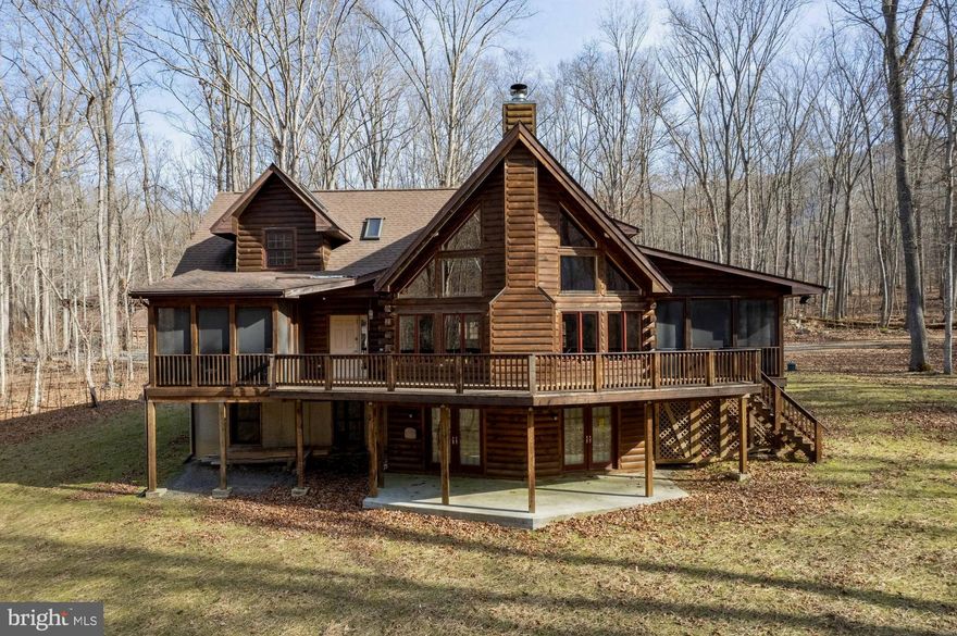 An Exceptionally Special Retreat with Cacapon River frontage of over 320 ft.! Situated on five acres of mature hardwoods and built in 2008, this Lincoln Log home offers a quiet haven in breathtaking natural surroundings. Taking advantage of the beautiful view, there are two screened porches and a large deck overlooking the river. There are three plus bedrooms, three- and one-half baths, a two-story great room with a beautiful high efficiency wood burning fireplace and a media room. But the lower-level arcade room will blow you away! Filled with arcade games, billiards, ping pong, etc., you will have limitless entertainment. The primary bedroom suite is on the main level, along with the kitchen, dining, powder, great and media rooms. The upper level has two en-suite bedrooms, a loft and reading nook. In addition to the arcade, the finished lower level has an office/bedroom and workshop. Hardwood oak tongue and groove floors and pine ceilings grace both the main and upper levels and most of the walls are pine logs, creating a warm and comforting environment. There are many small touches, both seen and unseen, that make this home a truly special sanctuary.  All furnishings, electronics and games convey making this turnkey home ready to enjoy now, make your appointment today!