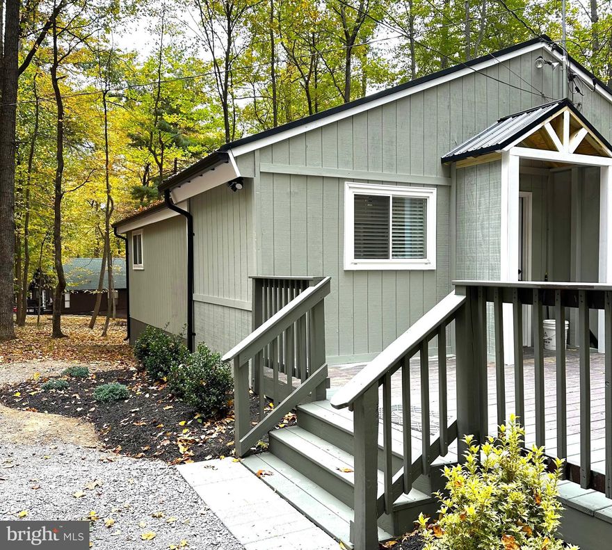 Nestled in the midst of nature's splendor is where you'll find this wonderful completely renovated cottage! Whether you are searching for a year-round residence, investment property, or vacation home, this Cottage in The Woods could be for you! The cozy 2 Bedroom home, 2 Bath with an additional office/flex space features a brand new metal roof, new windows and freshly a painted exterior. The inside features a electric fireplace surrounded by a stone tile wall, new LVP floors, fresh paint, new stainless appliances,  all new light fixtures and ceiling fans. High ceilings and great natural light connect you to the outdoors while still enjoying modern creature comforts. The outside features a sprawling, oversized deck with a wooden porch shelter. In addition, check out the large workshop with electricity plus lots of storge for your tools or garden. With a little less than 1 acre, you'll quickly forget you are within a short trip to the surrounding towns and villages. This property also boasts a Class B Membership, which gives you access to restaurant and clubhouse discounts, a Rec center complete with full gym, indoor sports courts, sauna, heated pool, spa and more. The 2 outdoor pools are very refreshing in the summer, and numerous other amenities like pickleball and tennis courts, sports field, and more are also available. Golf is available as a pay-for-play option.