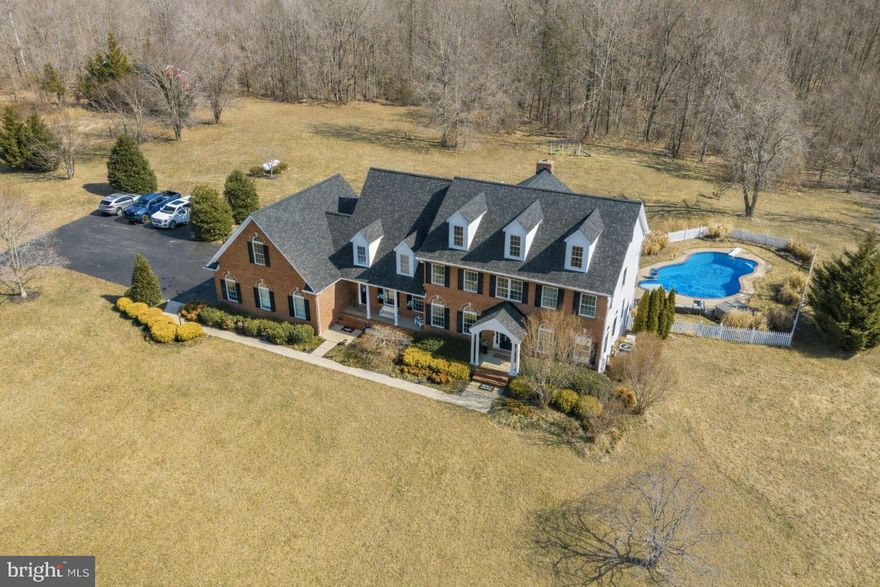 Lined with mature trees and backing to a peaceful stream, this stunning home offers the perfect blend of luxury, comfort, and everyday livability across 7 beautiful private acres. The setting feels like a private retreat, yet it’s still conveniently located for commuting with easy access to major routes. From the moment you arrive, the home makes an impression with its stately presence, two front entrances, and oversized three-car garage with storage above. Inside, you’ll find timeless details throughout, including wainscoting, crown molding, custom built-ins, and detailed woodwork that add warmth and character without feeling overdone. The main level is designed to make daily life easy while still feeling special enough for entertaining. The formal living and dining rooms are perfect for gatherings, while the enormous family room creates a comfortable place to relax, featuring both a fireplace and a pellet stove. The gourmet kitchen is truly the heart of the home, offering a large workspace, quality appliances, and an insta-hot faucet for added convenience. Just off the kitchen, the bright breakfast room and rear deck provide the perfect spots to enjoy morning coffee while taking in views of the trees and surrounding acreage. There’s also a first-floor office that could easily serve as a main-level bedroom if needed, along with a spacious laundry room featuring extra cabinetry, washer, dryer, and a laundry tub. Upstairs, each of the four bedrooms feels like its own private retreat, all featuring en-suite baths and great storage. The primary suite stands out with its huge sitting area, spa-style bath with soaking tub and separate shower, and incredible closet space designed to hold everything with room to spare. The mostly finished basement adds even more living and entertaining space with a large recreation room, entertaining area, and a cozy wood-burning stove with a classic brick hearth and mantle. Walk-out access leads directly to the backyard and pool area, making indoor-outdoor living feel seamless. There’s also an unfinished exercise space, tons of storage, and a rough-in for a future bathroom. Outside is where this property truly shines. The gunite pool creates a resort-like feel during the warmer months, and the hot tub is included as-is. The detached 30x40 barn-style building with concrete flooring offers endless possibilities for a workshop, hobby space, or storage. The partially wooded acreage offers privacy, natural beauty, and ample space for horses, if desired. Additional features include a water filtration system and a Generac generator hook-up already in place and being wired. Located in a small subdivision with no HOA, this property offers the freedom and space that’s becoming harder to find.This is the kind of home where everyday living feels a little more special, where entertaining is easy, and where years of memories are waiting to be made. A truly beautiful property inside and out.
** Senior pets on premises. They will be in the garage for initial showings, but can be removed for 2nd showings & inspections