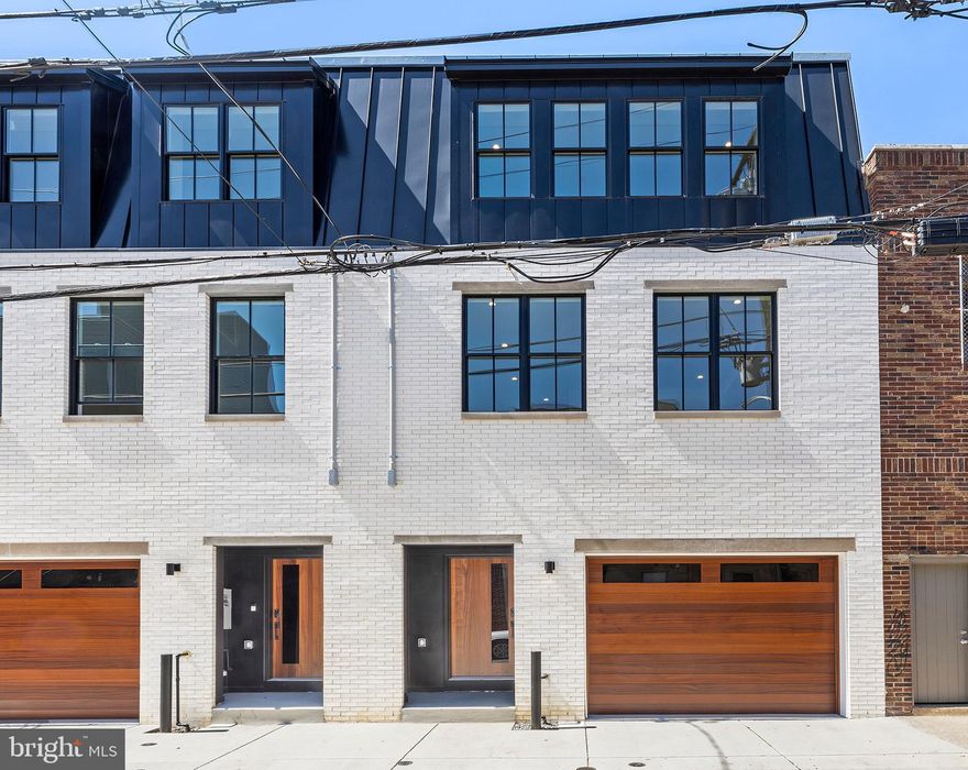 Last Home left at the Duo on Juniper. This extra wide, semi-custom Luxury New Construction Home with PARKING (and the ceiling height to install a car lift for a 2nd Car) and a Full 10 Year Tax Abatement*  was built with major attention to detail and design. This beauty sits on roughly a 21 foot wide by 85 foot deep lot and boasts 3,400/SF of above grade living and three outdoor spaces in the heart of Passyunk Square and within the Fannie Jackson Coppin School Catchment. Dual Zone, Multi-Unit HVAC, recessed LED lighting, smart locks, Nest Thermostats and Pella windows help make this 3 Bedroom + 2 Flex Room & 3 Full - 2 Half Bath Home, efficient & smart.10 Foot ceilings on the first floor is beautifully accented by white oak herringbone flooring to make the living space pop. Semi-custom Slim-Shaker contemporary cabinets are outfitted with Bosch 800 series stainless steel appliances and super-white quartzite countertops that waterfall off each side of the 10 foot island. This is a kitchen that chefs and entertainers alike with thrive in. Just off the kitchen there is plenty of space for the dining table of your dreams and plenty of space to set up a huge living space in almost any configuration. Step outside the the 8 foot patio slider into your 21 foot wide by 23 foot deep yard that makes for the perfect indoor/outdoor living scenario everyone has been craving since the pandemic. Also on the first floor you will find a powder room conveniently located next to the garage. Head up the custom steel stringer, solid oak tread staircase to the 2nd Floor and you will find two large ensuite bedrooms, both sun-soaked and with plenty of closet space. You will also find your first flex-room. Roughly 12x11 and suitable for whatever your mind can imagine, including a nursery, office, gym, playroom, etc. Just down the hall you’ll find a true, large laundry room that you will actually enjoy doing laundry in. Walking up the stairs to the 3rd Floor you will get natural light from both the patio sliding door and 2 skylights at the top of the pilot house. At the 3rd floor landing you will find your 2nd flex-room, complete with a wet bar, wine fridge, powder room and a glass patio slider that leads out onto a private terrace for easy entertaining and/or your morning coffee/night cap. A door for privacy leads into the Primary Suite where you will find two large walk-in closets on your right. To your left is the Primary Bath complete with a 72” double vanity, free-standing soaking tub, toilet and a 3 piece shower. Two sun-tubes in the bathroom provide plenty of light in the day without needing to turn the lights on! Walk just down the hall to the HUGE Primary Bedroom large enough for a California King, and extra sitting area and furniture. Built-in storage is also below the windows. Back down the hallway and up the stairs you will find your THIRD OUTDOOR SPACE, a full roof deck with 360 degree views of the city. This home is located in the heart of Passyunk Square and with a WalkScore of 97, it is within walking distance to some of the best amenities the neighborhood has to offer, including, Mighty Bread Co, ReAnimator Coffee, Columbus Square Park, Palizzi Social Club, Laurel, River Twice and just a short walk to the Italian Market. Steps from the Broad St Line also provide easy access to public transportation. Don’t let this one-of-a-kind home slip out from underneath your grasp.