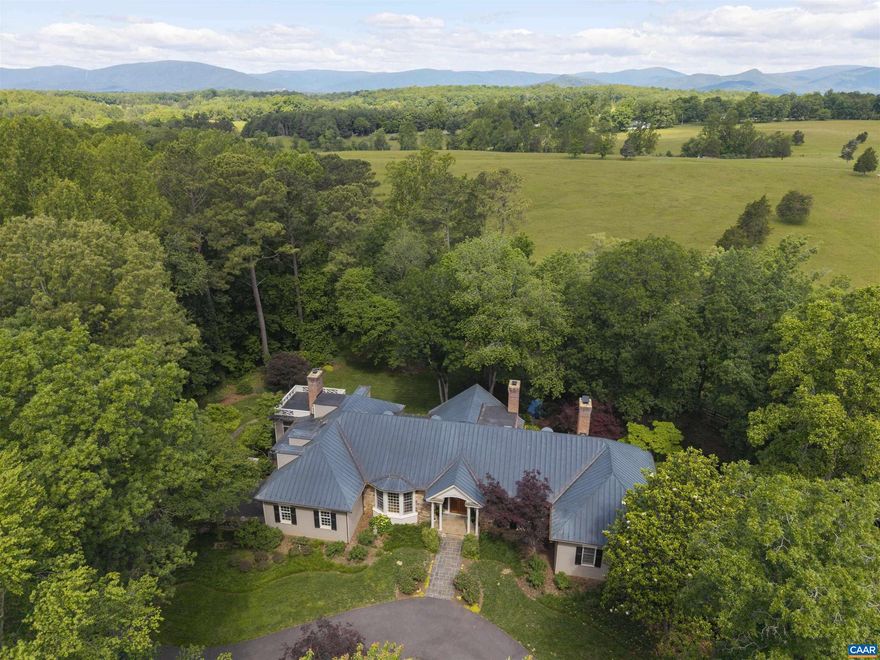 Set on 5.65 serene acres overlooking the protected 175-acre Foxfield Horse Race Course, this exceptional 5,500 sq ft custom home offers sweeping pastoral and Blue Ridge Mountain views from nearly every room. Designed by esteemed architect Henderson Heyward and masterfully built by craftsman John Anderson, the residence features a copper roof, stone and painted cedar siding, and striking architectural detail throughout. Expanses of glass frame the landscape, while the interior blends grand scale with livable comfort?gracious formal rooms, relaxed everyday spaces, and 9 & 10-foot ceilings throughout. Heart pine floors, four fireplaces, and exquisite trimwork reflect superior craftsmanship. The main-level primary suite offers luxurious one-floor living, with ample guest and family space upstairs. Nestled on a quiet dead-end lane just minutes from town, this property is ideal for entertaining or peaceful retreat. Lush gardens, ornamental trees, and a stunning four-falls water feature complete this rare offering.,Glass Front Cabinets,Granite Counter,Painted Cabinets,Fireplace in Family Room,Fireplace in Living Room,Fireplace in Master Bedroom,Fireplace in Study/Library