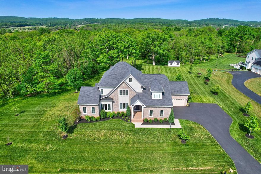 Welcome to 42438 Black Talon Ct, an extraordinary estate nestled in one of the most serene neighborhoods of Leesburg, Virginia. This opulent residence offers an unparalleled blend of sophisticated design, modern amenities, and exceptional craftsmanship—creating the ultimate sanctuary for those who desire an elevated lifestyle.
Spanning over 5500 square feet, this stunning 5-bedroom, 6-bathroom estate is a masterpiece of architectural elegance and thoughtful design. Tucked away at the end of a private cul-de-sac, the home commands breathtaking panoramic views of lush green landscapes and is surrounded by nature’s beauty, meticulously landscaped, offering a retreat from the bustle of everyday life.
Upon entry, you are captivated by the open floor plan featuring soaring ceilings, intricate moldings, and exquisite hardwood floors. The formal living and dining areas boast an air of refinement, with oversized windows that flood the space with natural light. These rooms are perfect for hosting intimate gatherings, with elegant detailing throughout. Off the left side of the home is the sought-after main level in-law suite with a large closet and private bath and walls of windows creating a bright and welcoming retreat. 
Anchoring the home is the grand family room a true gathering space, offering a fireplace as its focal point. High ceilings, recessed lighting, and a stunning wall of windows add to the space’s warmth and elegance. The kitchen is designed for the discerning culinary enthusiast, it features top-of-the-line appliances, custom cabinetry, expansive granite countertops, and a large island. Whether preparing a casual meal or hosting a grand dinner party, this kitchen effortlessly combines form and function. The adjacent breakfast area, framed by large windows, provides a cozy spot to enjoy morning coffee while soaking in the serene surroundings.
For those who enjoy seamless transitions between indoor and outdoor living, the home’s open-concept design extends effortlessly to the expansive outdoor living areas. Step out onto the large, covered deck or the beautifully landscaped patio which features a hot tub and fire pit, perfect for unwinding amidst nature’s tranquility. The private backyard is a true haven, with mature trees, a meticulously manicured lawn, and plenty of space for outdoor activities, additionally there is a shed in the yard providing the option of additional storage.

The home’s primary suite is a private retreat that exudes luxury and comfort. With its own private sitting area, custom walk-in closets, and a spa-inspired en-suite bathroom, the primary suite offers an unparalleled escape. The bath features dual vanities, a soaking tub with a picturesque view, a large frameless shower, and opulent finishes throughout, creating an atmosphere of complete relaxation.
Each of the additional bedrooms is generously sized, offering ample closet space and beautifully appointed bathrooms. The home also features a finished lower level, complete with a state-of-the-art gym, an additional bedroom and bath, and expansive space for storage. Additionally the lower level provides ample space with the possibility of adding an additional finished room.

For the car enthusiast or those in need of ample storage space, the home features a 4-car garage with high ceilings and plenty of room for storage.
Situated on over 4 acres, the home offers complete privacy while still being conveniently located near the vibrant town of Leesburg, with its renowned dining, shopping, and cultural offerings. Major commuter routes, including the Dulles Greenway and Route 7, are easily accessible, making it a perfect location for both work and leisure.
This home is not just a residence; it’s a lifestyle. From its breathtaking views to its meticulous attention to detail, 42438 Black Talon Ct offers the very best in luxury living. Experience it for yourself and make this extraordinary estate your forever home.