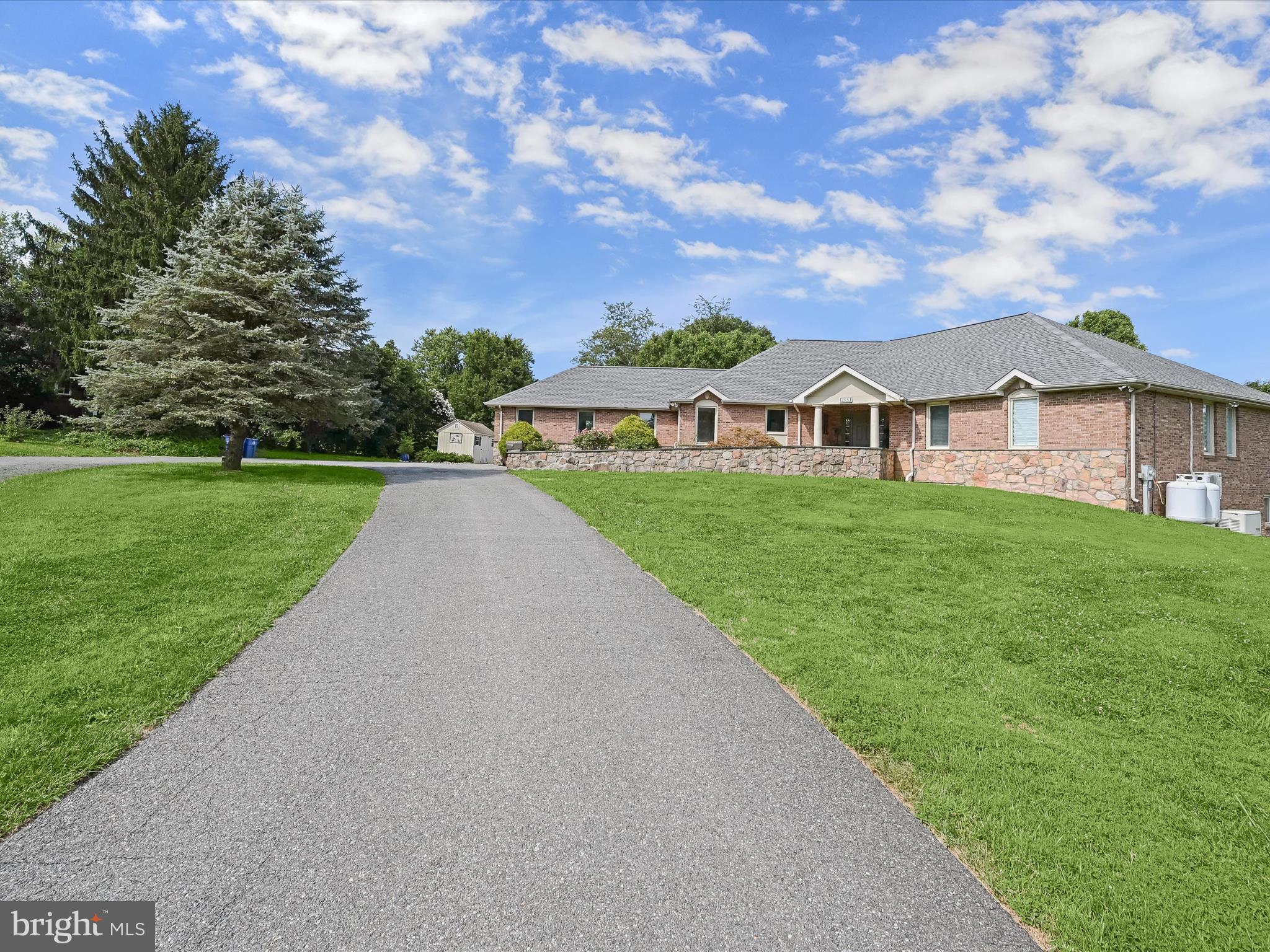 This spacious two-level rancher sits on a premium 1.5-acre lot boasts updates throughout including a new roof (2025), updated HVAC thermostat, newer dishwasher and fridge, a remote-controlled retractable awning, and an elevator for added accessibility, offering the perfect blend of comfort, space, and countryside charm, Inside, the main level includes dining and living rooms featuring beautiful hardwood floors, high ceiling, and a rustic stone fireplace that sets a cozy tone. A large sunroom with panoramic views brings the outdoors in and makes a great spot to relax year-round. The kitchen includes stainless steel appliances and a cozy nook, perfect for casual meals. The primary bedroom has its own en suite bathroom, walk-in closet, and even a laundry area for extra convenience. Take the elevator or stairs to the finished walk-out lower level providing tons of flexible space with additional bedrooms, two full bathrooms, a family room, and a rec room with direct access to the backyard. Enjoy the expansive outdoor setup, complete with a huge deck, screened-in gazebo, patio with built-in firepit, a heated swimming pool, play area, 2 large storage sheds, and even fruit trees including apple, fig, persimmon, and mulberry! Tucked away for privacy but still close to major commuter routes, shopping, dining, and entertainment, this one really has it all!