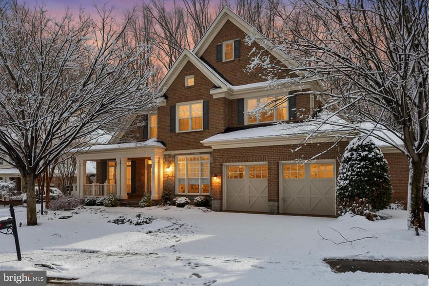 Welcome to 3555 Early Woodland Place offering a rare blend of elegance, comfort, and resort-style living in the heart of Fairfax. Set on a quiet street within the sought-after Picketts Reserve community, this 6-bedroom (including a main level primary suite), 5.5-bath residence immediately impresses with its stately brick and stacked stone façade, welcoming front porch, extended two car garage, and beautifully landscaped grounds. A spectacular in ground saltwater pool with adjoining hot tub, a custom multi area deck, and serene wooded backdrop create an atmosphere that feels both private and connected to nature. Inside, designer finishes, coffered ceilings, contemporary lighting, multiple two sided fireplaces, and a thoughtfully designed floor plan elevate every space.

The home opens with a grand two story foyer where hand laid hardwood floors lead into a formal living room warmed by a two sided fireplace and soft, modern paint tones. Across the foyer, the banquet sized dining room features refined moldings and a sparkling chandelier that sets the stage for memorable gatherings. A butler’s pantry and wine bar guide you into the gourmet kitchen, where granite countertops, handcrafted cabinetry, and commercial grade appliances—including wall ovens and a gas cooktop—create a chef’s dream. The center island with breakfast bar transitions seamlessly into a sunlit breakfast area and a cozy family room, both sharing the glow of another two sided fireplace. A glass paned door opens to the expansive composite deck and veranda, where stairs descend to the pool, hot tub, and patio framed by black iron fencing and lush trees, blending indoor and outdoor living with ease. The main level also includes a library or home office with an additional two sided fireplace, a powder room, a well appointed laundry and mudroom, and a private bedroom with en-suite full bath, ideal for guests or multigenerational living.
Upstairs, the primary suite serves as a luxurious retreat with a tray ceiling, a separate sitting room that opens to a private Trex balcony, and two generous walk in closets. The spa inspired bath features a dual sink vanity topped in granite, sumptuous jetted tub, frameless glass shower, water closet, and soothing tile finishes. A junior suite with its own bath and two additional bedrooms connected by an updated dual zone bath completes the upper level. The lower level offers an expansive recreation space designed for entertaining, complete with a built in wet bar, another fireplace, and direct access to the pool and patio. A theatre style media room promises cinematic evenings at home, while the 6th bedroom and additional bonus room, 5th full bath, and abundant storage add versatility and convenience.
Although the setting feels peaceful and secluded, the location remains exceptionally convenient. The Vienna Metro, I 66, Express Lanes, Route 29, and other major commuter routes are all within easy reach. Nearby shopping, dining, and entertainment options abound, including the vibrant Merrifield Mosaic District with its trendy restaurants, boutique retail, outdoor events, and the Angelika Film Center. For outdoor enthusiasts, the community offers numerous walking paths and convenient access to several nearby parks and a local golf course, providing plenty of opportunities for recreation and relaxation. For those seeking a home that pairs timeless craftsmanship with modern luxury in a premier Fairfax location, this home delivers an extraordinary lifestyle. Welcome home!