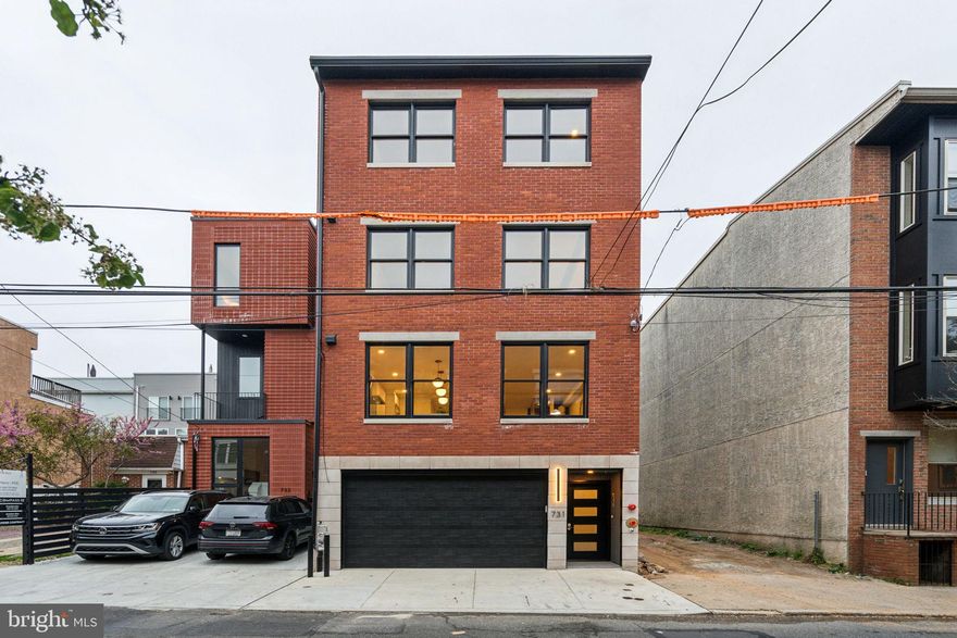 Welcome to 731 N. Uber St, a one-of-a-kind modern 3,800+/- sqft luxury home offering 4 bedrooms, 4.5 baths, hardwood floors throughout, a finished basement, dual-zone HVAC, 2-car garage and ELEVATOR. This beautiful new construction home has multiple outdoor spaces, including two fiberglass roof decks allowing for breathtaking, panoramic views of the city. Upon entering the home, one is greeted by a bright and airy open living space with dramatic 14 feet ceilings, recessed lighting and a gas, ventless fireplace that extends from floor to ceiling. The oversized windows flood the room with natural light that look out onto your private back patio, perfect for entertaining. Head up to the second level to your chef’s kitchen (or if loaded down with groceries, take your convenient elevator!), equipped with top-of-the-line appliances, including a Thermador refrigerator with a built-in water filter, Thermador gas range and hood, and a convenient undercounter microwave help make your kitchen life a breeze. A wide open dining area, glassed-in wine closet, more than enough cabinet storage and a bonus powder room round out the space to make entertaining effortless. Floating stairs take you to the third level, where you'll find two generously sized bedrooms, both en-suite, adorned with ample closets. The laundry room, complete with a Samsung washer and dryer, is conveniently situated on this floor. The fourth level of the home hosts the primary suite. It's comprised of a large bedroom filled with natural light, a walk-in closet with room to share, two additional closets and a sleek full bathroom adorned with a dual vanity, rainfall shower and separate commode room. A large fourth bedroom is also on this level with its own bathroom and walk-in closet. Ascend one more floating staircase and you will find the Crown Jewels of this home—Dual roof decks. Take in breathtaking views from the rooftop deck, offering panoramic vistas of the city skyline. Once you are done enjoying the skyline views, take your convenient elevator five floors down to the lower level. Here, you'll discover a large finished basement, making it an ideal space for a home gym, a state-of-the-art home theater, or a delightful children's play area. Fairmount Ave is half a block away and lined with top-rated restaurants and local shops. Whole Foods, Wine & Spirits, and Target are nearby, plus idyllic parks and iconic landmarks like The Philadelphia Museum of Art, Kelly Drive, and Eastern State Penitentiary are close. There's also easy access to I-676, I-76, Spring Garden St, Broad St, and public transit. *10 Year Tax Abatement Pending and 1 Year Builder's warranty.*