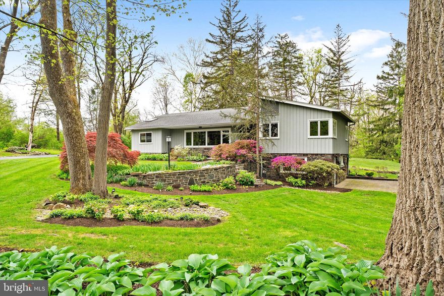 Tucked along one of Solebury Township’s most coveted roads, this well maintained ranch style home is set back in a peaceful, bucolic setting surrounded by mature landscaping, beautiful gardens, and a lush yard. The main level offers approximately 2,000 square feet of comfortable one floor living, complemented by additional finished space on the lower level that opens to grade and provides access to the rear and side yards. A welcoming foyer opens to two spacious bedrooms and a full bath with a tub/shower. The home then unfolds into an open concept living area where the living room, dining room, and kitchen flow seamlessly together. The living room features a gas fireplace, while the kitchen is appointed with granite countertops, JennAir double ovens, a Bosch induction cooktop, and a Bosch dishwasher. A sliding door from the dining area opens to a large deck, perfect for outdoor entertaining and relaxation, while a cozy sunroom also overlooks the rear yard. Just off the kitchen is the primary bedroom and the adjacent, renovated full bath with granite counters, a double sink vanity, a freestanding tub and a glass enclosed stall shower. Additional details of the main level include wood floors and walls, large windows to let in natural light, access to a walk up attic and access to the oversized two car garage. The partially finished lower level expands the home’s living space with an impressive 33’ x 23’ family/recreation room, complete with a gas fireplace and direct access to a charming side patio. An additional finished 20’ x 10’ room adjacent to the utility room offers space for a game or hobby room. The utility room houses the washer and dryer and provides access to two large crawl spaces for ample storage. Recent updates include newer HVAC and hot water heater, newer septic with final approvals granted in 2020 (documentation available upon request), and a generator that was recently serviced for added peace of mind. Ideally located just outside New Hope Borough and across the river from Lambertville, NJ, this property offers easy access to some of the region’s most beloved destinations for dining, shopping, and recreation while enjoying the privacy and tranquility of a truly special setting. NOTE: The property is being sold strictly as is and the buyer is to verify square footage/room measurements if important to them.