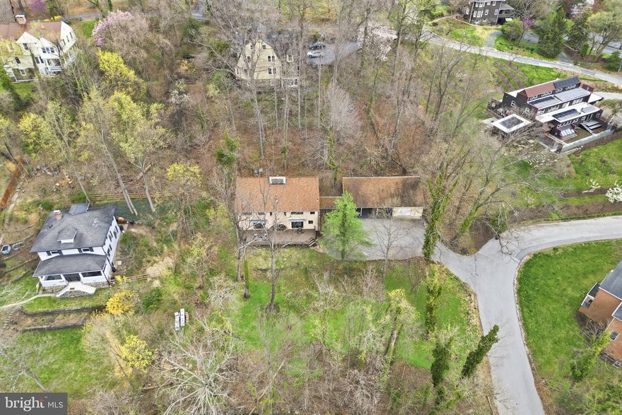 Don't miss this rare opportunity to own a beautifully unique and thoughtfully designed Contemporary/Mid Century Modern Style home in Mount Washington with unlimited possibility for everyday living! Tucked away on a private road in a 15-home community, custom-built, and sitting on .82 acres of wooded grounds there is really nothing else like it.  Approximately 4,875 square feet of living space with 5 bedrooms, 3.5 baths. This multi-level home is filled with character and endless potential for entertaining, featuring soaring cathedral ceilings, skylights, stone walls, slate flooring, built-ins, a wood-burning stove, a billiards room and other expansive entertaining spaces throughout. The kitchen is full of style and functionality while open to a large table space in the open main level that flows seamlessly from two points of entry to an expansive deck overlooking a green park-like setting perfect for outdoor gatherings. Upper levels include a spacious entertainment room with a stone bar, a private primary suite with cedar walk-in closet and dressing room or office, plus additional bedrooms, updated bathrooms and flexible living areas. Lower levels offer even more room for guests, recreation, storage, or customized use. Thoughtfully updated baths, appliances, roof, deck, HVAC, and more. 3 car carport and garage with expansive driveway makes parking multiple cars daily a breeze. Ideally located near top rated public and private schools, Mount Washington Village, Whole Foods, light rail, nature trails, parks, Sinai and Mount Washington Pediatric Hospital GBMC, and Johns Hopkins Hospitals, and easy access to I-83 and 695. This Amazing Value is A MUST SEE!