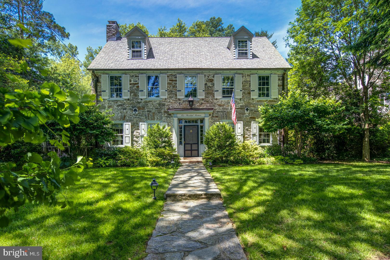 Curb appeal abounds in this center hall stone colonial, on a tree-lined street in a fantastic walk-to-everything location in the heart of Chestnut Hill. This exceptional home is set back on a deep lot with mature landscaping, off-street parking and two car garage. A charming stone path leads to the front door and center entrance hall. The large formal living room has deep windowsills and built-ins, and a fireplace that's flanked on either side by French doors that lead to the gracious screened-in porch with slate floors. The sunlit dining room with deep windowsills leads to the gourmet kitchen with gorgeous custom cabinetry, granite countertops, Thermador oven/range, Sub-Zero fridge, Bosch dishwasher, under counter wine fridge and window overlooking the side yard. The kitchen opens to the rear family room with walls of windows looking out on the extensively landscaped backyard, ample built-in shelving with window seat, and doors to the side porch. An updated powder room off the center hall offers marble floors and pretty glass tile backsplash. The second floor private master bedroom suite offers tons of windows overlooking the yard, a large walk-in closet, and master bath with oversized shower and lovely custom double vanity. Lovely princess suite with totally renovated full bath, walk-in closet and convenient laundry room. A third bedroom suite with full bath completes the second floor. The third floor features 2 bedrooms and full bath with large clawfoot soaking tub. The real treat of this property are the extensive stone paths, mature trees and landscaping, quaint English garden with raised garden beds - perfect for a vegetable or flower garden, multiple patios and firepit area. A garden shed and 2-car garage in the back of the property are accessed from Meade Street. Sit on the side porch or on the rear terrace with family and friends and listen to the summer concert series at Pastorius Park, just a short stroll away! Truly a wonderful, central location close to Highland Train Station and everything Chestnut Hill has to offer. Don't miss this opportunity!