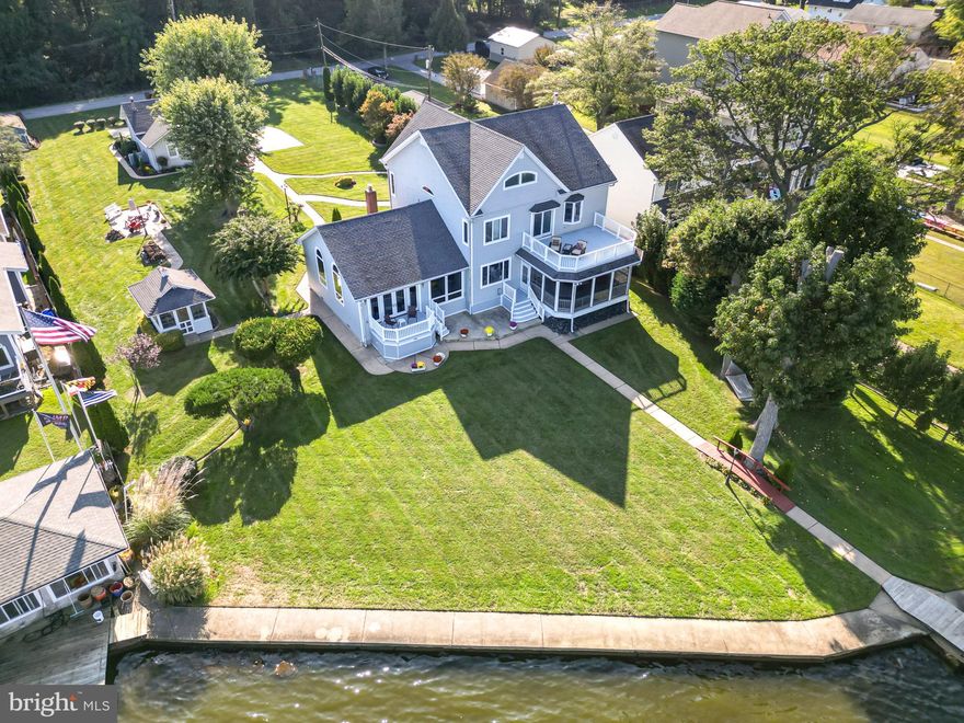 Welcome to this absolutely phenomenal 3 story waterfront home in Sparrows point on a large beautiful lot.  This is a custom built, well maintained, 3 story, 4,266 sf waterfront home with expansive views of Rocky Point and Hart Miller Island, situated near the mouth of Back River. This home has two sheds, a crab shack/gazebo, 2 car garage with workshop and second level, a boathouse, and pier with a few boat slips.  The house itself has a main level bedroom suite with full bath, a 3 season room, and decks on the first and second level.  There is a total of 5 bedrooms and 3.5 baths.  This house is gorgeous and has everything you dreamed of!  The extensive pier/dock area includes a 20,000 pound boatlift, a grandfathered-in covered boathouse with two lifted slips and adequate dockage for additional watercraft. Water depth average 4'.  The house itself is set back from the street on a large manicured lot.  Pull into the large driveway and park on the 4 car parking pad and take a short walkway among the landscaping up to the large covered front porch.  Walking in this beautiful home brings you to a tiled foyer that has a wide tiled hallway that leads through the main floor straight to the rear door.  To the right is the gourmet kitchen with a massive granite island, custom maple cabinetry, with under cabinet lighting, high end stainless appliances,  multiple sinks and more.  Adjacent to the kitchen is a butler pantry with cherry wood cabinetry, another sink, compact dishwasher and refrigerator.  Passing through the butler pantry leads to a massive great room.  This room is where you want to spend your time, flush with windows giving you a clear picturesque view of the water behind the home.  This massive room has 13' vaulted ceilings, a gas fireplace with two tiered mantle and French doors that lead out onto a rear deck and patio.  This room circles into a formal dining room with a tray ceiling, chair rails and crown molding and a large picture window overlooking the gorgeous water views.  There are French doors on both side of dining room in case privacy or quiet is desired.  The other side of the dining room leads back into the main hallway.  Back in this hallway is a large walk in laundry/mudroom, a first floor powder room, as well as a main floor owners suite.  This bedroom has its own private entry/exit to the rear sunroom, a walk in closet and private bath with jacuzzi tub and walk in shower.  French doors from this bedroom and the main hallway both lead out into the rear three season room with its own wet bar that gives you views and access to the rear yard and water beyond. Off of this room is another uncovered deck and patio below.  This patio has walkways that connect it with the dock, all other patios and structures and every entrance and exit to the home.  Back inside, taking the stairs to the second floor brings you to a full bath with tub/shower combo, and three bedrooms, including a second primary suite with a large walk in closet, and private bath with a soaking tub overlooking the water, and a stand up shower.  This room has French doors that also open out onto a private second story deck with amazing views.  Taking the next set of steps to the third floor brings you to another living area with a 5th bedroom, also with its own private bath.  There are extra rooms for storage up on this level as well.  
This house has it all, every thing was thought of and done with extreme care.  The home has so many custom upgrades and was done with remarkable quality.  Please ask your agent for the list of upgrades and benefits to this home that is enclosed in the documents of this listing.  You will be blown away!  Come see your new waterfront oasis today!