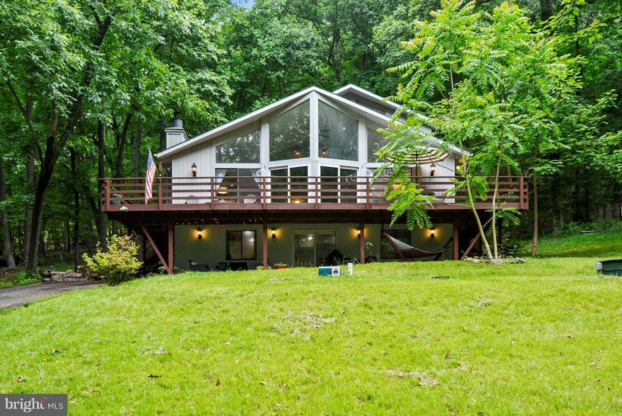 Mountain retreat with refined touches throughout. Great room w/ vaulted ceilings, STONE FIREPLACE, hand-scrapped hardwood floors & floor to ceiling windows opens to wrap around DECK. Kitchen w/ GRANITE COUNTERTOPS, SS appliances, pendant lights & breakfast bar. Master bedroom w/ spacious walk-in closet & REMODELED BATH. Fully finished lower level w/ Rec Room, 4th Bedroom, full bath & "pub room".