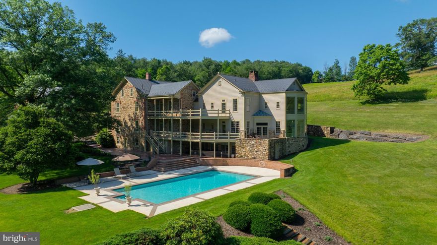 Welcome to your executive retreat — a one-of-a-kind estate offering the ultimate in privacy, space, and sophistication. Nestled on 68 pristine acres in the east end of York County, this extraordinary property is the perfect sanctuary for discerning buyers who value both seclusion and elegance. From the moment you enter the 1,000-foot long driveway, framed by immaculate landscaping and breathtaking stonework, you’ll know you’ve arrived at a property unlike any other.

The 10,000+ square foot residence seamlessly blends timeless farmhouse charm with modern luxury, having been thoughtfully expanded and updated with the highest level of craftsmanship. Inside, you’ll find an open and airy layout designed for entertaining and showcasing — ideal for hosting large family gatherings or intimate gatherings with your friends. The grand great room is a true centerpiece, boasting 20-foot ceilings and a dramatic wall of windows that frame stunning views of the natural surroundings.

The gourmet kitchen is a chef’s dream, featuring expansive granite countertops, custom cabinetry, and premium appliances — all designed to impress and inspire. Throughout the home, every window offers a picturesque view: from the serene, oversized stocked pond to the lush grounds where deer, wild turkeys, and foxes roam freely.

The second level presents two luxurious owner’s suites, plus a versatile bonus room currently used as a premier office — perfect for the executive working from home in style. The finished lower level provides even more flexibility, ideal for a guest or in-law suite with private access.

Car enthusiasts and collectors will be thrilled with the array of outbuildings and garages, offering ample space for vehicles, recreational equipment, or a private workshop — all without the worries of bothering your neighbors. The inviting in-ground pool completes this extraordinary offering, delivering resort-style relaxation just steps from your door.

This estate is positioned perfectly in York County in that you have easy access to Rt 30, Sam Lewis State Park and all the many attractions that both York and Lancaster Counties have to offer!

This is more than a home — it’s a lifestyle. A rare opportunity to own an unparalleled property that offers privacy, luxury, and room to dream. Come experience it for yourself — you’ll fall in love at first sight.