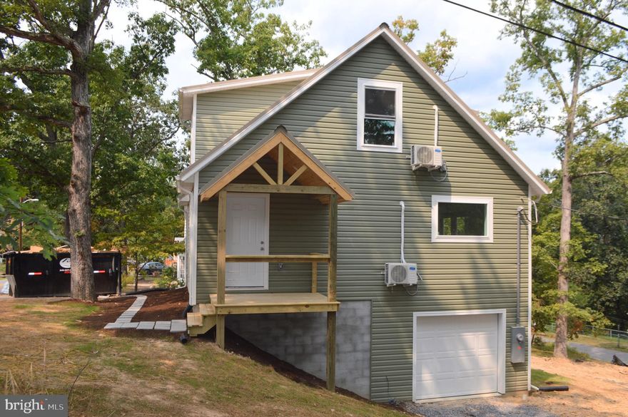 This brand-new Craftsman-style Cape Cod offers the best of both worlds—close to the heart of Berkeley Springs yet tucked among mature trees for privacy and a peaceful country feel. Featuring 3 bedrooms and 2 full baths, this thoughtfully designed home includes a main-level primary suite for convenient one-level living. The open-concept kitchen shines with a large island, perfect for gathering, cooking, and entertaining.
Upstairs, you’ll find two spacious 11x14 bedrooms along with an open sitting area that can also serve as a home office or flex space. The unfinished basement offers endless potential with a rough-in for a full bathroom, plus a front-entry garage for easy access. Seller is offering a $3,000 credit toward a stove, refrigerator, and dishwasher, allowing you to choose the appliances that fit your style.
Enjoy a brand-new home in a serene setting just minutes from shops, dining, and all the charm of downtown Berkeley Springs.