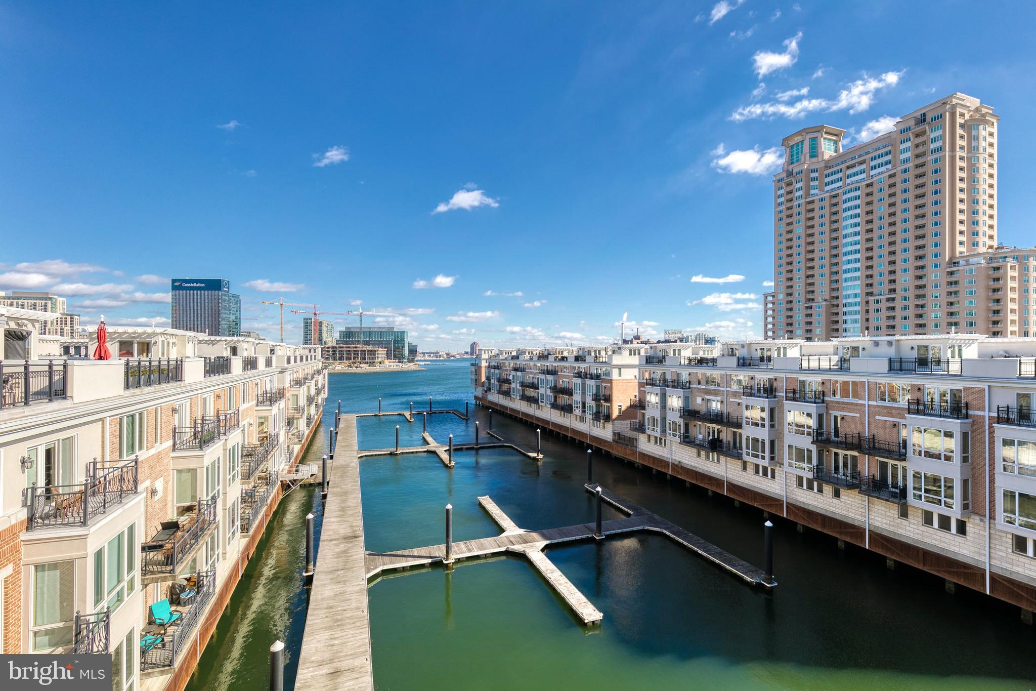 Waterfront living at its finest! This gorgeous and Fully Furnished 2 bedroom, 2 full-bath and 1 half-bath Pier Home with private elevator and two-car garage parking is located in the exclusive gated Harborview community on Baltimore’s Inner Harbor. The home has everything you need and is move-in ready. It offers over 2,750 square feet of living space over five levels, three private waterfront balconies, and an incredible roof top deck with stunning panoramic harbor views. The open concept second level boasts tall ceilings, a large gourmet kitchen with stainless steel appliances, granite counters, gas cooking, an abundance of cabinet storage, and bar seating. The focal point of the combination living area/dining area is the magnificent unobstructed harbor view through the floor to ceiling windows , which is enhanced by the inviting gas fireplace accented by a beautiful stone wall and custom shelving. The second level also has a separated powder room. One floor up is the elegant primary suite with two oversized walk-in closets and a luxurious primary bath with double sink vanity, walk-in glass enclosed shower, and soaking tub. A laundry area is conveniently located off of the primary bedroom hall. The fourth level offers a spacious second bedroom and full bathroom off the hallway. There is a large second living room/ family room with water views, another water front balcony, and a wet bar. The exceptional rooftop terrace is the cherry on top with astonishing views of the Inner and Outer Harbor, the Baltimore skyline, the iconic Domino Sugar sign, Federal Hill, and Fourth of July fireworks. This home is complete with an oversized two-car garage with ample room for storage and an additional two-car parking pad. The community includes a host of community amenities and services: 24-7 security, an outdoor pool, private fitness center, private guest parking garage, onsite gate attendant, package acceptance, pristine landscaping, trash and snow removal, and more. Located on Baltimore’s ‘country club’ side of the harbor, this home has direct access to the harbor promenade and is perfect for an evening stroll with easy access to restaurants and local shops. The Pier Homes Community is also ideally located close to Historic Federal Hill, I-95, BWI, Penn Station, I-83, and Baltimore’s Downtown and Harbor East Business Districts. Schedule your appointment to see this furnished home today!