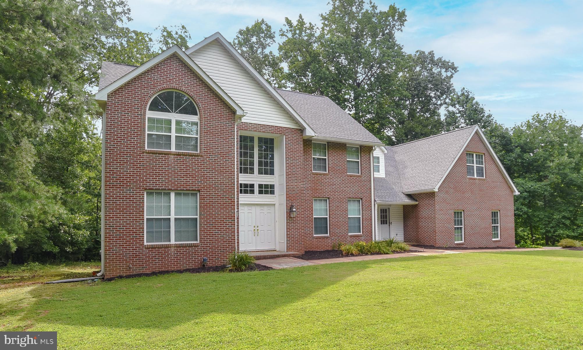 Experience custom craftsmanship both inside and out with this brick colonial home situated on 2 private acres in the highly desirable Summerwood neighborhood.
Just 7 miles from NAS Pax River, this home provides the best of both worlds - convenience and quiet country living! Upon entrance, you are warmly greeted by beautiful oak hardwood floors that carry through the formal living and dining rooms and up the homes central grand staircase.
This homes bright and open floor plan seamlessly connects the 2 story living room to the kitchen featuring ample cabinet space and a breakfast room with A large glass door leading out to an inviting spacious deck overlooking your sunny backyard. The main living level also features a main floor bedroom, laundry room and oversized 2 car side entry garage. Upstairs you’ll find a primary suite with vaulted ceilings, two walk in closets and ensuite bathroom with double vanities. The second floor also features two additional bedrooms, a hall bathroom and a bonus room/fifth bedroom that provides additional flexibility to this homes floorpan. Ready for you to finish - A full walk out basement with rough in bathroom and building materials that convey to finish the space. Once finished this home would have over 5,600 square feet! Recent Updates include a 2 zone GeoThermal system in 2016; new Roof and Gutters 8/2018.