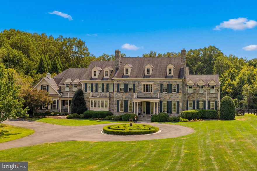First time offered for sale, this exceptional 5-acre estate is nestled at the end of a private road 
surrounded by lush gardens and mature trees. The custom designed field stone manor home boasts timeless elegance and offers over 12,000 Sq ft of living space.   A circular drive framed by boxwoods leads you to the grand portico. Entering the home, grandeur unfolds with soaring 12’ ceilings, luxurious cornice moldings, wide plank floors and a towering 2 story wall of windows looking out to the verdant backyard.  The two-story foyer with double curved staircase and in-laid rosewood compass medallion in the center are breathtaking. The main level features elegant formal rooms grand in scale and include a living room and dining room with period fireplace mantels and antique lighting. Unique features include a butler’s pantry hidden behind pocket doors, custom designed pine library, extra wide hallways, a separate guest coat closet, formal powder room and light-filled conservatory with double doors opening to the porch. The kitchen boasts Sub-Zero, Viking Professional, and Thermador appliances as well as custom cabinetry and a large island with warming oven.  A sunken family room flows off the kitchen with custom built-ins, floor to ceiling stone fireplace with gas logs and large windows bringing in lots of light. A morning room is off to the side with
double doors leading to the backyard terrace and fountain. The first floor includes a pantry, catering kitchen with additional Sub Zero, mudroom with cubbies, half bath and sports closet. Two separate staircases lead to the upper level where 5 spacious bedrooms with en-suite bathrooms can be found. Arches mark the hallways to each end of the house. The laundry room has linen closets on each side of the entry door, built in cabinets and shelves for folded laundry. A children’s library with built-in bookshelves and window seats for storage can be found at the end of one hallway while the master suite sits at the other end. A circular entry foyer with inlaid wood medallion leads to the master bedroom where a sitting room with gas fireplace, coffered
ceiling, 2 expansive walk-in closets and separate cedar-lined closet await. The bath is adorned with Carrera marble, dual vanities, whirlpool tub beneath a Palladian window and walk-in marble shower. The lower level includes a sports game area designed for 3 TVs to keep up with games or play X-Box; custom bar area, billiards room, sitting area with fireplace, exercise room, half bath, au pair suite with en-suite bathroom and 2 storage closets. A professionally designed and installed home theater features Klipsch surround sound and leather seats. A custom-designed wine cellar accommodating over 800 bottles features a built-in humidor. The outdoor patio with towering stone fireplace, built-in gas grill and bar are designed for year round enjoyment and ideal for gatherings under the stars. Formal gardens with boxwood hedges and fountain set the stage. A 50’ x 20’ heated pool with retractable cover and hot tub are hidden off to the left. Stone pillars with an antique gate frame the exit from the pool area to he rest of the property. There is room for tennis/pickleball courts or for a barn and riding ring. The garage has 2/3 parking spots including a double bay for a large SUV. A parking area outside the garage accommodates additional cars.  This property boasts 4-zone HVAC, updated water heater and water monitoring system, water purification system and pressure systems, whole-house CAT5 wiring and audio, and a 30-year Grand Manor roof. <iframe width="560" height="315" src="https://www.youtube.com/embed/vRgKKRW7To4?si=SMmUkCT3A0XRgD9g" title="YouTube video player" frameborder="0" allow="accelerometer; autoplay; clipboard-write; encrypted-media; gyroscope; picture-in-picture; web-share" referrerpolicy="strict-origin-when-cross-origin" allowfullscreen></iframe>