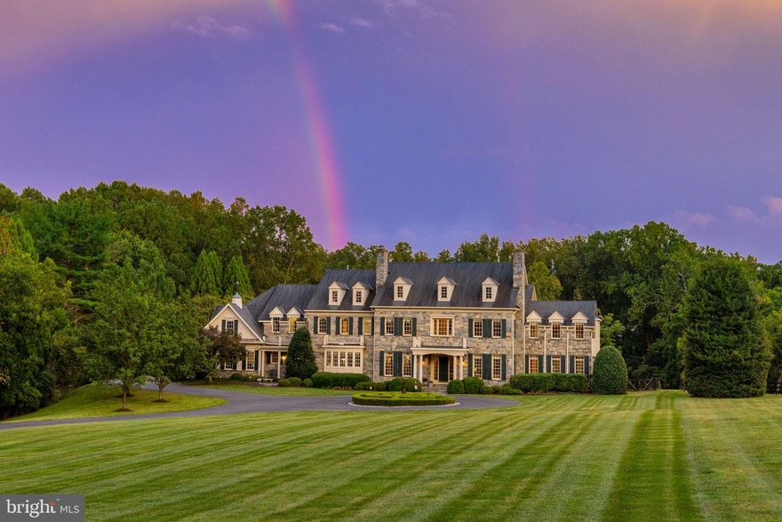 First time offered for sale, this exceptional 5-acre estate is nestled at the end of a private road
surrounded by lush gardens and mature trees. The custom designed field stone manor home boasts timeless elegance and offers over 12,000 Sq ft of living space.   A circular drive framed by boxwoods leads you to the grand portico. Entering the home, grandeur unfolds with soaring 12’ ceilings, luxurious cornice moldings, wide plank floors and a towering 2 story wall of windows looking out to the verdant backyard.  The two-story foyer with double curved staircase and in-laid rosewood compass medallion in the center are breathtaking. The main level features elegant formal rooms grand in scale and include a living room and dining room with period fireplace mantels and antique lighting. Unique features include a butler’s pantry hidden behind pocket doors, custom designed pine library, extra wide hallways, a separate guest coat closet, formal powder room and light-filled conservatory with double doors opening to the porch. The kitchen boasts Sub-Zero, Viking Professional, and Thermador appliances as well as custom cabinetry and a large island with warming oven.  A sunken family room flows off the kitchen with custom built-ins, floor to ceiling stone fireplace with gas logs and large windows bringing in lots of light. A morning room is off to the side with
double doors leading to the backyard terrace and fountain. The first floor includes a pantry, catering kitchen with additional Sub Zero, mudroom with cubbies, half bath and sports closet. Two separate staircases lead to the upper level where 5 spacious bedrooms with en-suite bathrooms can be found. Arches mark the hallways to each end of the house. The laundry room has linen closets on each side of the entry door, built in cabinets and shelves for folded laundry. A children’s library with built-in bookshelves and window seats for storage can be found at the end of one hallway while the master suite sits at the other end. A circular entry foyer with inlaid wood medallion leads to the master bedroom where a sitting room with gas fireplace, coffered
ceiling, 2 expansive walk-in closets and separate cedar-lined closet await. The bath is adorned with Carrera marble, dual vanities, whirlpool tub beneath a Palladian window and walk-in marble shower. The lower level includes a sports game area designed for 3 TVs to keep up with games or play X-Box; custom bar area, billiards room, sitting area with fireplace, exercise room, half bath, au pair suite with en-suite bathroom and 2 storage closets. A professionally designed and installed home theater features Klipsch surround sound and leather seats. A custom-designed wine cellar accommodating over 800 bottles features a built-in humidor. The outdoor patio with towering stone fireplace, built-in gas grill and bar are designed for year round enjoyment and ideal for gatherings under the stars. Formal gardens with boxwood hedges and fountain set the stage. A 50’ x 20’ heated pool with retractable cover and hot tub are hidden off to the left. Stone pillars with an antique gate frame the exit from the pool area to he rest of the property. There is room for tennis/pickleball courts or for a barn and riding ring. The garage has 2/3 parking spots including a double bay for a large SUV. A parking area outside the garage accommodates additional cars.  This property boasts 4-zone HVAC, updated water heater and water monitoring system, water purification system and pressure systems, whole-house CAT5 wiring and audio, and a 30-year Grand Manor roof.  The park-like grounds create a sense of seclusion despite being minutes from Tysons Corner,Dulles Airport and Beltway. This property offers a perfect balance of privacy, elegance and convenience giving a sense of tranquility that feels worlds away from the hectic pace of city life. 1205 Towlston Road is more than a home—it’s a legacy property designed for timeless living and grand entertaining.