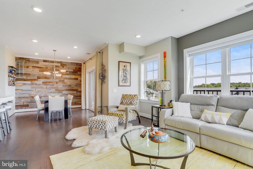 Welcome to 2905 Bleeker Street, Unit 405, where luxury, comfort, and convenience come together in this corner penthouse at The Flats at MetroWest. Perfectly positioned in Fairfax, this home offers seamless access to everyday essentials, including shopping, dining, and parks just minutes away.

Inside, you’re greeted by east-facing windows that welcome natural light throughout the day. The open-concept layout features wood flooring, upgraded bedroom carpeting, and custom wood plank accent walls that add warmth and modern elegance. The gourmet kitchen is both stylish and functional with upgraded granite countertops and tile backsplash; modern lighting flows seamlessly into the dining and living areas. A private deck invites you to enjoy peaceful, tree-lined views.

The master suite offers comforting touches with Hunter Douglas programmable blinds and an additional blackout shade, while the primary bath includes custom pull-out shelving for added organization. The guest bedroom is enhanced by a built-in custom wall unit, and the guest bathroom’s marble vanity elevates the space.

Additional features include in-wall TV mounts, dimmable lighting, and a Natural Comfort-brand HVAC system with an air scrubber for optimal air quality. Two side-by-side garage parking spaces, conveniently located near the elevator, complete this exceptional home.

Commuting is effortless with quick access to I-66, I-495, Route 50, and Route 29. The Vienna/Fairfax-GMU Metro Station is just one mile away, and nearby Fairfax Connector buses and VRE/Amtrak services provide excellent transit options to Washington, D.C. and more.

Don’t miss the opportunity to experience refined penthouse living with thoughtful upgrades, stunning views, and unbeatable convenience. Schedule your private tour today!