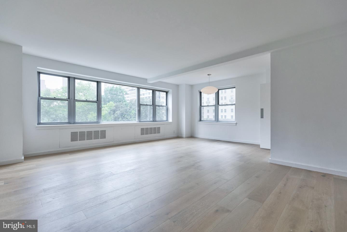 This spacious corner unit boasts a grand living room and dining room with large windows showcasing treetop views of Rittenhouse Square. The designer galley kitchen features gas cooking, brand new white cabinetry with silver drawer pulls, a Miele stacked washer/dryer and high-end stainless steel appliances. Enter the master suite through a large dressing area with a walk-in closet, hall closet and ensuite bathroom with a glass enclosed shower. The second bedroom is also spacious in size. There is a nearby full hall bathroom with a shower/tub. Additional highlights include new oak, wide plank hardwood floors; amazing storage space; and lots of natural light throughout. 220 W. Rittenhouse Square is a doorman building. Membership to the building's fitness center is $100 annually per person. There is a $150 move in and move out fee. Pets are not permitted. Rent includes all utilities plus cable TV.