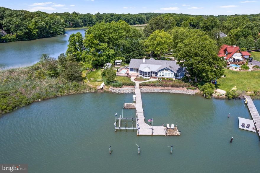 Waterfront home in historic Galesville on serene Lerch Creek. This 2,300+ sqft Coastal Rancher provides 3 bedrooms and 2.5 baths on the main level including a separate office space as well as an additional 700+ sqft of living space with full bath above the detached 3 car garage.  Let the worries of the world melt away as you travel down the private driveway to your personal oasis on Lerch Creek. The beautiful landscaping draws you into and around the property and showcases the special features including the romantic swing with gazebo, expansive composite deck with swim spa and retractable awnings and large screened porch. All perfect locations for relaxing and soaking in the waterfront lifestyle and water views! The private pier with water, power, lighting, 20,000lb lift and 2 launching docks optimizes the enjoyment of your time on the water and you are ideally sited for quick access to the West River and the Chesapeake Bay. Inside, the open floor plan with tons of windows, hardwood floors and water views from almost every room is captivating.  The family room with soaring ceilings, newly enlarged kitchen with island, living room with fireplace, dining room with wood stove and spacious primary bedroom ensuite all look out across the landscaping to the sparkling waters of Lerch Creek. The 2 additional bedrooms and studio apartment above the garage appreciate the views of the lush and colorful landscaping.  Galesville is known great waterside dining at Pirates Cove and Stan & Joe’s plus the West River Sailing Club for membership, lessons and competition.  The West River Yacht Harbour has a pool, picnic tables and grilling.  Galesville Estates is just 30 minutes to downtown Annapolis and under an hour from DC, Northern VA and Baltimore. Located close to neighboring parks, walking trails, restaurants, grocery stores and schools; this peaceful setting is a great weekend get-away or forever home. Welcome Home!