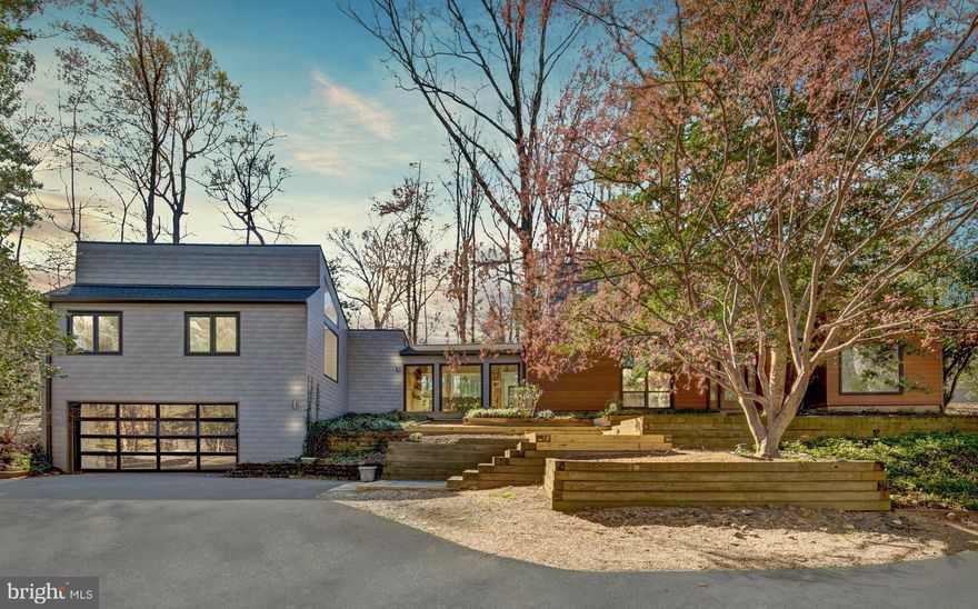 **Multiple Offers Received. Please Submit by noon on 4/15/2024 at 3:00 PM**

Nestled within the tranquility of a pristine one-acre lot in Oakton, VA, lies a mid-century modern masterpiece that redefines privacy and connection with nature. This unique residence, marked by its innovative design, features two distinct wings bridged together by a dining room encased in expansive floor-to-ceiling windows. This architectural choice not only showcases the breathtaking natural surroundings but also bathes the interior in natural light, creating an ambiance of warmth and openness.

The exterior, with its top-of-the-line Canadian aluminum siding that mimics real wood grain, sets a new standard for contemporary aesthetics. Inside, the main level reveals the owner's suite as a sanctuary of peace and luxury, boasting hardwood floors, large windows that frame the enveloping forest, and a modern bathroom outfitted with a standalone tub and seamless shower. This intimate retreat offers perfect relaxation while immersed in the serene views of nature, blending seamlessly with the home’s mid-century charm and modern comforts.

Central to the home's design, the kitchen and adjoining spaces serve as the vibrant core of this residence, distinguished from the tranquility of the separate sleeping quarters. The kitchen itself is a modern marvel, equipped with stainless-steel appliances and abundant cabinetry, creating a spacious area for culinary exploration or social gatherings. It seamlessly transitions to a large stone patio, a wonderful outdoor haven perfect for entertaining, set against the backdrop of thoughtfully landscaped grounds and a minimalist fence that harmoniously merges with the natural environment. This configuration underscores the home's thoughtful design, separating the lively communal areas from the serene privacy of the bedrooms.

The home's orientation and hilltop position allow for unmatched visibility and sunlight throughout, emphasizing the harmonious relationship with the surrounding forest. The long driveway, flanked by trees, accentuates the architectural splendor, leading to a serene entrance. 

This property does not shy away from modern conveniences, featuring a new roof, windows, insulation panels, gutters, furnace, A/C, water system, skylights, hardwood flooring in the main level and a renovated kitchen with quartz countertops, an Italian range, and two dishwashers. The built-in wireless pet gate and the nearly invisible fence ensure freedom and safety for pets, blending technology with nature.

Located in an enclave of lush greenery amidst the bustling areas of Reston, Tyson's Corner, Fair Oaks, and Fairfax, this property provides the perfect balance of tranquil living and urban convenience. Easy metro access bridges the gap to city life, ensuring the best of both worlds. Within this serene retreat, one can listen to the symphony of nature, where the gentle murmur of a water fountain intertwines with the calls of cardinals and bluejays. All this, set against the backdrop of a meticulously modernized home that not only preserves but elevates its original mid-century essence.