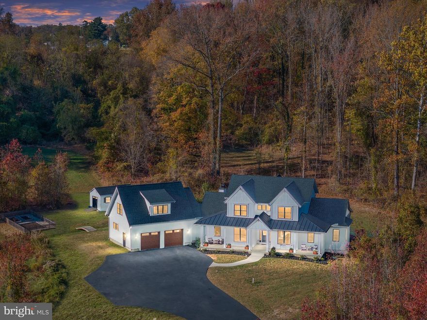 Set on 8 sprawling acres in the prestigious Governors Crossing community, 3910 Jiggsy Court in Edgewater, MD is more than just a home—it’s a statement of unparalleled luxury and exquisite living. From the moment you arrive via the sweeping private driveway, the grandeur of this 2020 custom-built farmhouse craftsman takes your breath away. The stately full front porch invites you to pause and take in the serenity of this exclusive estate before stepping into a sun-drenched haven of sophistication and style. Inside, soaring ceilings, walls of windows, and bespoke finishes create an atmosphere of refined elegance. At the heart of the home lies a gourmet kitchen that’s nothing short of a chef’s fantasy, complete with gleaming white maple cabinetry, quartz countertops, top-of-the-line stainless steel appliances, a wet bar, wine fridge, double wall oven, three dishwashers, and an expansive walk-in pantry. Whether hosting grand soirees or intimate gatherings, this kitchen is where culinary dreams and cherished memories come to life. The first-floor primary suite is a sanctuary of indulgence, offering a spa-inspired bathroom with a glass-enclosed rain shower, a soaking tub, and double vanity, as well as direct access to a backyard paradise. Outside, your private resort awaits—a heated saltwater pool with a retractable cover and cascading waterfalls, tiered patios, and a wood-burning fireplace that set the stage for unforgettable moments, from poolside summer soirees to cozy winter evenings under the stars. Upstairs, four spacious bedrooms and a luxurious aupair/in-law suite with its own kitchenette and private living area provide room for everyone, while the fully finished lower level is an entertainer’s dream. Here, a rec room, billiard room, full bar, gym, craft room, safe room, and cozy den ensure there’s space for every passion and occasion. As if the interiors weren’t captivating enough, the outdoor space elevates this home to a league of its own—imagine hosting glamorous gatherings, roasting marshmallows by the fire, or simply soaking in the tranquility of the surrounding natural beauty. Perfectly blending elegance with livability and designed for those who refuse to settle for ordinary, 3910 Jiggsy Court isn’t just a home—it’s a lifestyle, a masterpiece, and a once-in-a-lifetime opportunity to claim your dream. Don’t let this jewel slip away—schedule your private tour today and experience the magic for yourself.