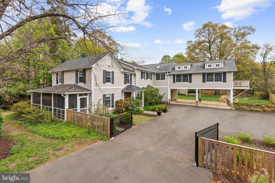 Welcome to this extraordinary custom modern-day farmhouse, blending timeless charm with modern elegance, sitting on just over half an acre of beautifully landscaped land. The property includes a piece of history, as it features the original farmhouse dating back to the late 1700s, which now houses two charming rooms off the foyer and screened in porch. In 1988, the original farmhouse was raised off its old foundation and set upon a new base of concrete piers and I-beams. Then, in 2007, it was lovingly renovated and expanded to create the exquisite custom farmhouse you see today. With 4,360 sq. ft. of above-grade living space and an additional 536 sq. ft. of unfinished space below grade, this home offers 5 bedrooms, 4 full bathrooms, and 2 half bathrooms. The expansive, fenced-in backyard backs to tranquil trees, offering privacy and serenity. Main Level: As you approach, you’ll be greeted by a stunning foyer with dual generous-sized coat closets and a half bathroom. The original farmhouse parlor rooms are just off the foyer, complete with a screened-in porch and one of the two staircases leading to the upper levels. The seamless integration of the original farmhouse with the newer addition creates an inviting atmosphere with high ceilings, 10-inch crown moldings, baseboards, and recessed lighting throughout. The gourmet kitchen is the heart of this home, showcasing custom two-toned cabinetry, two dishwasher drawers, and a large center island with two layers of honed granite, featuring a prep sink, microwave drawer, and built-in sweep vacuum. Enjoy cooking with the imported AGA 4-door stove that includes a wok burner, simmer burner, and a companion 2-door oven with 4 burners, dual fuel, and turbo convection. The custom granite farmhouse sink, paired with an atrium window, provides a bright and welcoming space for meal prep. Adjacent to the kitchen, the intimate dining room offers a convenient yet private space for family meals and entertaining. The living room is perfect for relaxing or hosting guests, featuring a corner gas log fireplace, a coffee bar/wine area complete with a 20-bottle wine rack, sink, wine fridge, and ice maker. Access the private patio through this space, where you’ll find a waterproof deck roof above and a landscaped backyard beyond. Rounding out the main level is a practical mudroom, located just off the 2-vehicle carport and through the second main entrance into the home.  Upstairs, the expansive second staircase leads you to the bedroom level. Bedroom 2, above the carport, offers versatility as a large bedroom, office, extra living space, or entertainment area, and includes an en-suite bathroom. The primary bedroom is a serene retreat, featuring hardwood floors, cathedral ceilings with skylights, elegant wainscoting, a gas fireplace, and French doors that open to a newly constructed Trex deck, perfect for evening relaxation. The primary bathroom is a luxurious sanctuary, complete with a walk-in shower, double vanity, 2-person soaking tub, and skylights. Two additional bedrooms share a convenient Jack and Jill bathroom, with the laundry area just across the hall. At the end of the hallway, you'll find another spacious bedroom with a charming full bathroom, complete with wood beam accents. The unfinished basement offers a wealth of possibilities for expansion, with 536 sq. ft. of space ready for your vision. Whether you’re looking to create a private home theater, an expansive game room, a gym, or even an in-law suite, the blank canvas of this basement allows for endless customization. Its high ceilings and open layout provide the perfect foundation for transforming this area into the additional living space you've always dreamed of. With the right design, this space can significantly enhance the home’s overall value and functionality. This property is truly one-of-a-kind, blending historical character with modern luxury. Welcome home!