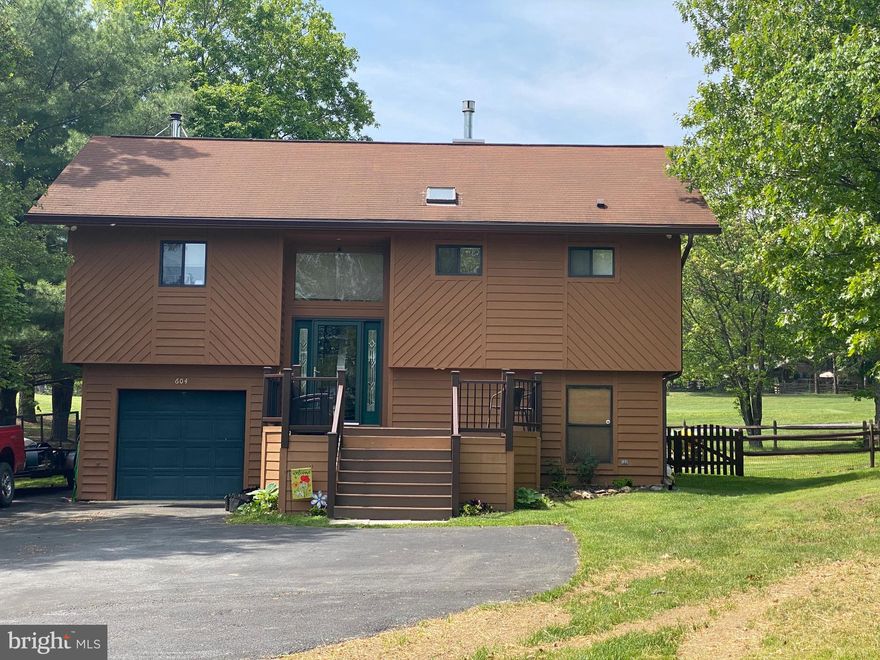 A split foyer house design is a rare find at The Woods Resort, but it fits so many lifestyles you will want to visit this one.   This Redbud model is located on the 17th fairway of the Mountain View Golf Course. One level living on the upper level features a huge open living space with cathedral ceiling and both a fireplace and wood stove to keep you cozy in cold weather months.  The kitchen features a convenient layout for meal preparation and huge peninsula for baking, party buffet or quick meals.  A room addition serves as a formal dining room or could be "flex space" with direct access to the rear deck for easy grilling and entertaining in warm weather months.  The primary bedroom and bath are also on this level and provide maximum privacy. Features a cathedral ceiling, two closets and sumptuous bath with 5' shower stall, oversized vanity and dressing console. The additional bedrooms and second bath are on the lower level.  Children or guests can have their own space.  Single car garage with additional storage space can be accessed from the lower level.  Outdoor living space includes a multi-level front porch for visiting with friends and neighbors or a more private setting on the rear deck for relaxing around a firepit or enjoying your favorite beverage.  This mountain side, golf course community offers lots of amenities, please check them out on the Internet.
