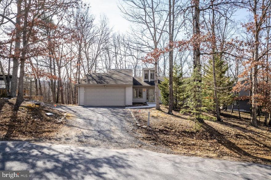 Enjoy one-level living in this bright and sunny Massanutten home! Tiled foyer, spacious and open living/dining area with floor-to-ceiling stone work, and 16-foot vaulted shiplap ceiling. Built-ins in dining area. Large eat-in kitchen with skylight, built-in desk area, and extensive cabinetry. 8x15 sunroom with 4 skylights and tiled floor. Primary suite has soaking tub, tiled shower, and skylight! 2nd full bath in hallway has tiled shower and skylight. All three bedrooms have 12-foot vaulted ceiling. 9x9 laundry room with utility sink, double attached garage. Two decks on either side of sun room -- smaller one off the dining area (ideal for grilling), and larger one (8x22) off the primary suite. Backs up to green space. Great opportunity for prospective home owner or investor!