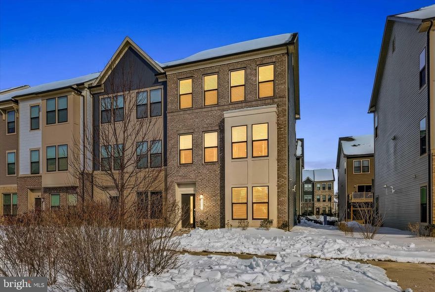 Immaculate and exquisitely appointed, this three-level end-unit Halston model townhome in the prestigious Watershed community offers the rare opportunity to enjoy nearly new construction without the wait. Freshly painted and meticulously maintained, the home showcases refined finishes, thoughtful upgrades, and an unmistakable sense of luxury throughout-making it truly move-in ready.

The entry level welcomes you with a stylish foyer and a private living space highlighted by a dramatic accent faux-brick feature wall that adds warmth and designer character. A full bath on this level provides ideal flexibility for guests, multigenerational living, or a sophisticated home office, while the oversized two-car garage offers exceptional storage and everyday convenience.

The main level impresses with an expansive open-concept design curated for upscale entertaining and effortless daily living. The gourmet kitchen is a true showpiece, featuring premium stainless steel appliances, an oversized quartz island, custom designer backsplash, upgraded cabinetry, and updated pendant and recessed lighting. Custom window shades and abundant natural light enhance the adjoining cafe area and spacious family room, while an oversized powder room and exceptional closet storage add rare and highly desirable functionality. Step outside through the screened door to a large composite deck-perfect for al fresco dining, evening gatherings, or quiet moments of relaxation.

The upper level is anchored by a luxurious owner's suite spanning the rear of the home, offering a serene retreat with a generous walk-in closet and a spa-inspired bath with an oversized walk-in shower and refined finishes. Two additional well-proportioned bedrooms, a beautifully appointed full bath, and a conveniently located laundry area complete this level, creating an ideal balance of privacy and practicality.

Thoughtfully designed across all three levels, the home offers both open gathering spaces and private retreats, providing exceptional flexibility for today's lifestyles and multigenerational needs.

Set within the highly sought-after Watershed community, this residence offers access to exceptional lifestyle amenities and a naturally beautiful backdrop adjacent to the Patuxent Wildlife Refuge. Residents enjoy a state-of-the-art clubhouse with fitness and wellness spaces, co-working areas, and social lounges, as well as an outdoor pool, dog parks, playgrounds, community gardens, and miles of scenic walking and biking trails. The community's meticulously maintained grounds and contemporary design create a luxurious environment that feels both modern and tranquil. Watershed is centrally located near premier shopping, dining, and essential commuter routes. With quick access to Routes 32, 295, 100, I-95, 495, and 50, this home offers a highly convenient commute to Washington, D.C., Baltimore, Annapolis, BWI Airport, Fort Meade, NSA, NBP, DISA, US Cyber Command, and other major employment centers. This pristine, (so please remove shoes) beautifully upgraded townhome combines luxury, comfort, and an unbeatable location-making it an exceptional opportunity in one of Anne Arundel County’s most desirable communities.