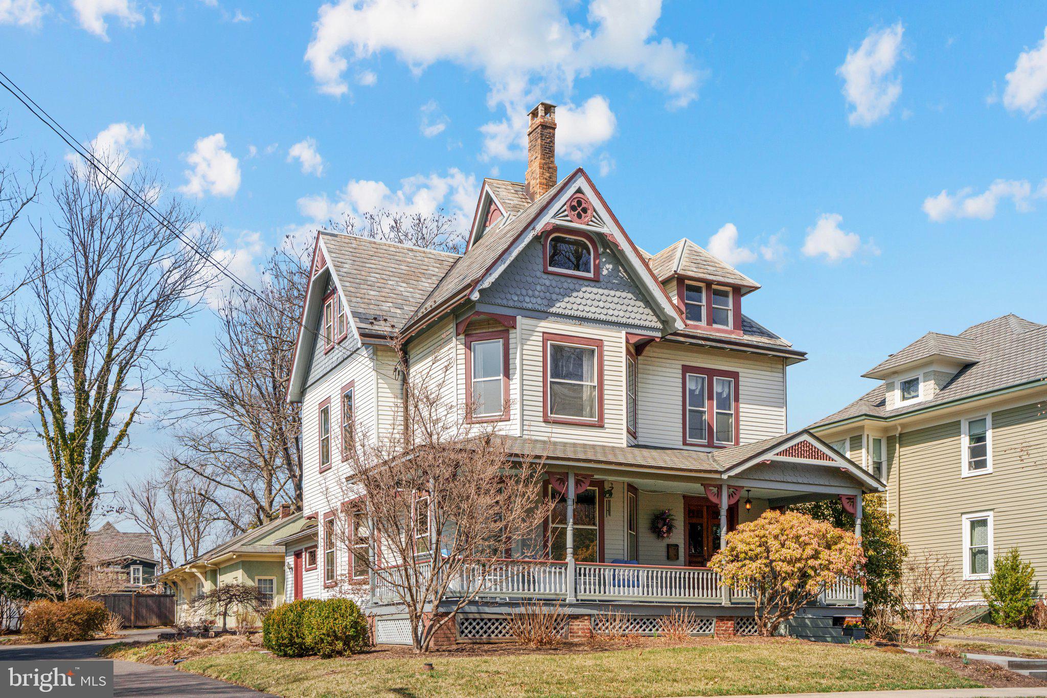 Welcome to 110 N. Lincoln Ave in the heart of Newtown Borough. This beautiful Queen Anne style home has many original features along with all the mod-cons. You enter from the walkway to a huge wrap around porch. The grand foyer offers a chestnut staircase, a window seat and a hand carved newel post. A nice sized living room has pocket doors leading to the family room. This room offers wonderful views through the oversized windows and all the comfort of a custom fireplace in Arts and Crafts style with Moravian tiles, representing the seasons and the Tree of Life. The family room also provides access to the first floor powder room. An ample sized dining room leads through to the only addition to the original building, a beautiful gourmet kitchen and breakfast area with butler’s pantry housing some of the original cabinetry.
The turned staircase leads to the second floor which offers 2 bedrooms, a hall bath and a primary suite with a sitting room and full bath. A third floor main suite has a large bedroom, a good sized bathroom, a huge closet and an office.
The property is almost half an acre and has some beautiful trees and horticultural specimens that you can enjoy from the bluestone patio. The back building is a three car garage, a wood work shop, a potting shed and attic.
This home has been lovingly restored and cared for by the current owners (only the 4th owners since the property was built in the late 1890s).
Whether it’s cozy nights curled up by the fire, a fine day reading on the porch or a balmy evening on the patio with a glass of wine, this home offers it all. Welcome to 110 N. Lincoln Ave… Maybe you are home already!