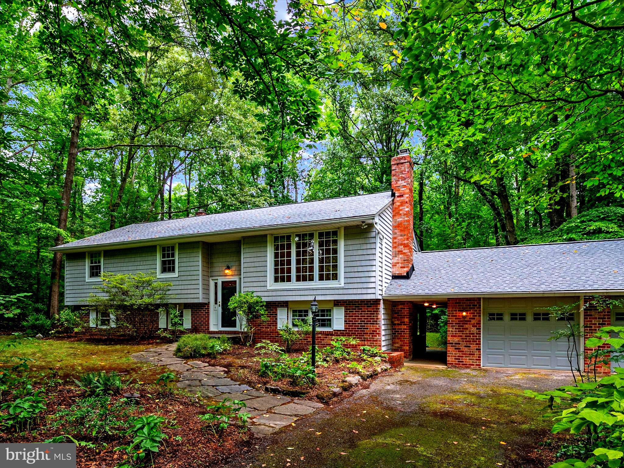 If you seek privacy, tranquility, and a connection with nature, look no further. Nestled amidst lush trees and verdant shrubbery, this home offers a serene retreat in a natural paradise filled with woods, plants, and wildlife. Relax by the peaceful backyard pond and waterfall or unwind in the quiet, cool screened-in porch.
The living room, dining room, and kitchen seamlessly flow onto an outdoor deck and private rear yard with expansive views of the surrounding trees.
On the main floor there are three bedrooms, while the lower level presents numerous possibilities such as an office, den, or potential in-law suite complete with a kitchenette and full bath. Stay cozy in the winter months with a wood-burning stove.
Additional highlights include a spacious two-car garage and ample off-street parking. Brand new well water system with state of the art technology. With your personal touch and improvements, transform this house into your perfect home.