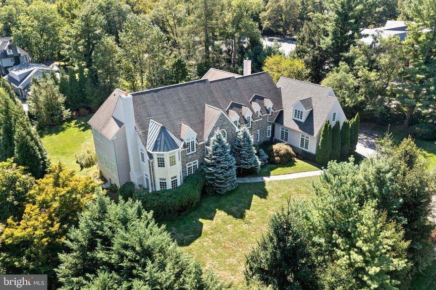Welcome to 225 Fishers Road, a magnificent stone manor home within walking distance of some of the best schools, restaurants, and entertainment the Main Line has to offer. Situated on approximately one acre of level land, the home presents itself as a formal old-world Main Line estate, yet offers the most modern amenities, combining luxury and elegance with state-of-the-art architectural details and top-of-the line finishes. Mature landscaping creates a private and stately setting. Once inside, you are welcomed by the 2-story reception hall that sets the tone for the rest of the home. Beautiful hardwood floors are found throughout, and an abundance of extra-large windows provide all-day natural light. Soaring ceilings and detailed millwork define the superior artistry that makes this home all that it is. To your left is the stunning formal living room with a gorgeous wood burning fireplace. To the right, the spacious formal dining room is perfect for entertaining guests. An adjoined butler's pantry flows into the gourmet kitchen, which features granite countertops, high-end stainless-steel appliances, an abundance of cabinetry, and a large center island. The kitchen opens to the bright breakfast room and cozy family room keeping everyone connected. Two separate sun-filled first-floor offices are private and will make working from home much more comfortable and productive. Two powder rooms complete this floor. Main and rear stairs ascend to the second floor where you will find five spacious bedrooms, all with ensuite baths. The luxurious primary suite includes a sitting area, a large walk-in closet with custom built-ins, and two ensuite bathrooms with a connecting glass-enclosed shower and a relaxing sunken jacuzzi tub. The four additional bedrooms are nicely sized, and each have their own ensuite bathrooms and walk-in closets, creating convenience and privacy. The large laundry room with two washers and two dyers completes this floor. The third floor is an unfinished attic that can be renovated into additional living space. Down in the lower level you will find an abundance of space for recreation and relaxation, as well as plenty of storage areas. The flagstone patio is the perfect place to entertain or peacefully enjoy the stately grounds around you. The attached three-car garage conveniently opens into the kitchen and back stairs.  3 zoned HVAC system installed in 2021 and  newer hot water heater. This magnificent home is ideal for both entertaining and everyday family living, with multiple comfortable living spaces, refined interior and exterior finishes, and central location close to anything you could want or need.