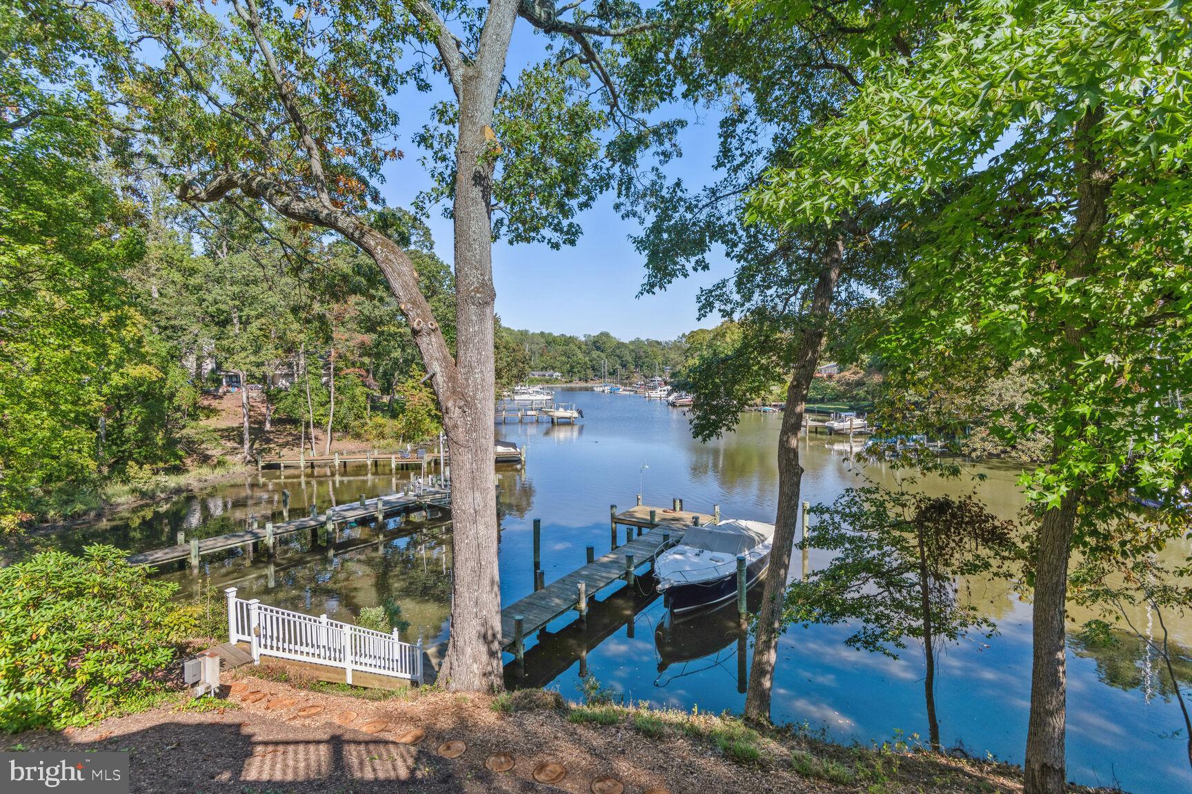 Introducing a coastal gem with artistic touches… Nestled by the waterfront, this property offers a luxurious blend of functional design and artisan craftsmanship. With approximately 2,000 sq. ft. of Timbertek decking, relax on the master bedroom's private balcony with soft down-lighting or lounge on the carefully crafted deck seating under the bow window's gentle glow. Walk along durable brick pathways, set on deep concrete foundations, leading to a driveway masterfully designed by Driveway Impressions of Annapolis. Complementing these is a picturesque stone garden and meticulously crafted stone structures by Earth Design. Inside, the radiant Australian Cypress wood floors set the stage. Hand-painted touches by renowned Annapolis artist, Cindy Fletcher Holden, grace the kitchen and living spaces. The kitchen boasts Corian counters, top-tier appliances, and British hand-painted decorative tiles. All exterior wall-mounted lights and door fixtures are crafted from Baldwin's enduring lifetime brass, a testament to the home's commitment to quality. Add in modern conveniences like a powerful generator, and tech-ready provisions, and this residence is both a haven of luxury and a masterpiece of design. Embrace this harmonious blend of comfort, artistry, and coastal living. The mean low water is over 6 feet at the private dock. Incredible views up Lake Ogleton which leads out to eh Severn River and Chesapeake Bay respectively. Adjacent lot that is an approx 0.47 acre waterfront parcel with public sewer can be purchased separately for $400,000 or can be combined with 1011 Dulaney for $2,950.000. Engineering has not been done but the lot could be a fabulous accessory dwelling unit (ADU) for this property or an opportunity to maintain the privacy you already have. More details available upon request. Don’t miss out!