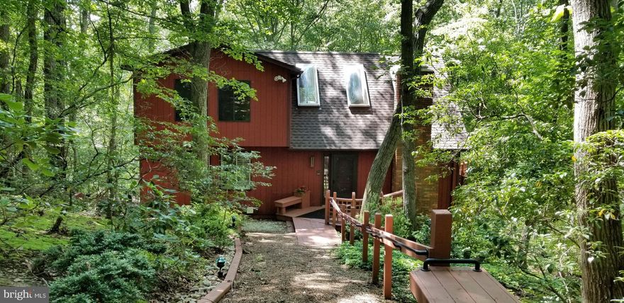 Please continue to show the property to non-contingent buyers. 72 hour kick-out in place. Private Contemporary home in a forest like setting with 2 acres. Paved long driveway with over sized 2 car detached garage and upstairs bonus room. Tucked in the woods this home features tons of windows, wrap-around deck, screened in porch, walk-out basement and views of the woods from every room. Two story living room with vaulted ceilings made from California Redwood, wood burning fireplace, skylights, glass sliding doors open to wraparound deck and screened in porch. Open living-dining room layout is great for entertaining guests. Kitchen with breakfast bar and separate bar sink. First floor master bedroom suite. Second floor has two bedrooms, loft office area, private balcony and full bathroom. Lower level has large family room, wood burning fireplace and glass sliding doors with walk-out access, small kitchen, full bathroom, laundry room and utility room. Mature trees and low maintenance landscaping. No HOA fee, new skylights, new roof and new septic.