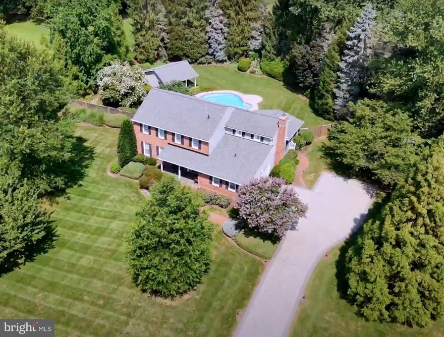 Elegant brick-front colonial home set on over two private acres in sought-after Equestrian Park. Tucked away on a quiet cul-de-sac, this exceptional residence offers rare privacy, resort-style outdoor living, and refined interior spaces just minutes from Metro, major commuter routes, and Dulles Airport.
A picturesque stone driveway leads to the home, where manicured grounds unfold into an extraordinary outdoor setting. The expansive fenced backyard is designed for both relaxation and entertaining, featuring a heated in-ground pool, a cabana/pool house, and a large, screened porch overlooking the grounds. Beyond the main yard lies a separate recreation area with private tennis and pickleball courts, tennis house with viewing porch, and an open lawn, creating a truly unique estate-like retreat.

Inside, timeless architectural details and quality finishes define the home, including hardwood floors, crown moldings, plantation shutters, and Roman shades throughout. The gourmet kitchen is thoughtfully designed for both everyday living and entertaining, anchored by a large granite island with seating and appointed with stainless steel appliances, including a Professional Service Thermador Triple Oven with warming drawer, standard oven, and microwave, a Thermador six-burner cooktop with pot filler, Zephyr chef’s hood, wine refrigerator, slate backsplash, and under-cabinet lighting. A formal dining room sits just off the kitchen for elegant gatherings. The family room with raised brick hearth fireplace opens through French doors to the screened porch, seamlessly connecting indoor and outdoor living. Additional main level spaces include a formal living room and generous family gathering areas. The luxurious primary suite offers a private sitting room and a beautifully renovated spa bath featuring floor-to-ceiling tile, double vanity, walk-in shower, and custom walk-in closet with built-ins. The finished lower level provides exceptional flexibility with a large recreation room, separate den/workroom, and a third full bath, ideal for entertaining, guests, or home office use.

The home also features Lutron smart lighting, double-pane storm windows, and Schlage electonic locks on doors with remote monitoring. Extensive system upgrades include new HVAC (2024) with steam humidifier, Air Knight air purification system, and remote Carrier system management app, 105 gallon Rheem Marathon hot water heater, and new roof (under 2 years). Propane tank for the pool heater is under 2 years old. Remote programmable management capability for in-ground Rainbird Sprinkler system. Verizon FIOS and Cox Internet are available.  A rare opportunity to own a private luxury retreat on over two acres in one of Fairfax County’s most desirable communities.