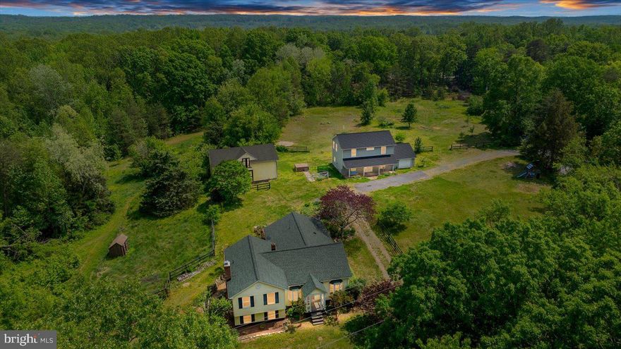 Two residences... on nearly five total acres... with an expansive barn and separately open and fenced spaces ready for all of your farmette dreams? 41 Richards Ferry Road in Stafford County wows on absolutely every level! The estate here dates back to 1939 and has been under its current owners’ care (with updates aplenty!) since 2016. Between the two homes, there are six total bedrooms, four baths and 4,000 square feet of living space to relish. The acreage here spans 4.75 acres and there are no HOA fees. Zooming in on the front yard, it’s one of many fenced-areas! The land is nestled on the corner of a private road, with a gravel driveway culminating in an L-shape. Before we zoom in on the two residences, let’s talk about all that comprises this dynamic acreage! Highlights include a two-story barn (as big as a house!) equipped with three stalls, a tack room, electricity, a water pump and hay loft and shoot. Next to it are multiple fenced-in areas and a charming goat shed. For animals, this is heaven! Beyond it is a path for
hiking/riding as well as an area primed for a shooting range. Note the fruit trees and bushes throughout – apple, peaches, pears, blueberries, blackberries, raspberries and figs all grow here! Let’s check out the secondary residence here first – it was totally redone and updated in 2017 (and we mean totally, including insulation, plumbing, flooring and more)! It includes three bedrooms, an office and two full baths across its two total levels. For parking, there is a one-car garage. For soaking in the farm landscapes, this residence has a wonderful front porch with a swing. Through the front door of the secondary residence, it’s open bliss with a dining room and kitchen. The kitchen includes butcher block counters, black appliances and a big farmhouse sink. Off the kitchen is a window-draped family/living room. The entire downstairs is so light and airy! Upstairs, you’ll find three bedrooms, a full bath and the office. The primary bedroom includes a walk-in closet and the bathroom has two sinks, a tub/shower combo and a laundry set-up in the bathroom. For storage, there is attic access upstairs. Now, let’s head to the main residence, shall we? Its roof was updated in 2019 and all three exterior doors and select window components were recently replaced. The home follows a split-level floor plan with three total bedrooms and two baths. Heading inside, you’re greeted with hardwood flooring and arched entries. Main level highlights include the dining room, a piano room and the kitchen which includes a dining nook, walk-in pantry, granite countertops, solid-wood cabinetry and a double sink. The ceiling in the kitchen soars! We have a main level primary suite too, including a big bay window, giant closet and updated ensuite bath. Upstairs and within the primary residence are two bedrooms and a full bath (walk-in shower). Both of these bedrooms include updated flooring, three windows and two closets. The primary residence also has a basement with a recreation space with a large wood stove; an office; laundry room; crawl space; and exit to the outdoor space. Systems-wise, the HVAC was updated in 2022. Note the paver patio here with a wonderful goldfisth pond and then access to the 7-person hot tub (both residences have seamless access to the hot tub!). Beyond this incredible acreage, multiple grocery, shopping and dining selections are accessible along Route 17 within 10 minutes. For recreation, Curtis Park and the Gauntlet Golf Club are 5 minutes north. I-95 access is less than 15 minutes southeast (Route 17 exit) and the heart of Downtown Fredericksburg is within 20 minutes. 41 Richards Ferry Road is a wonderful home with so many options and opportunities!
