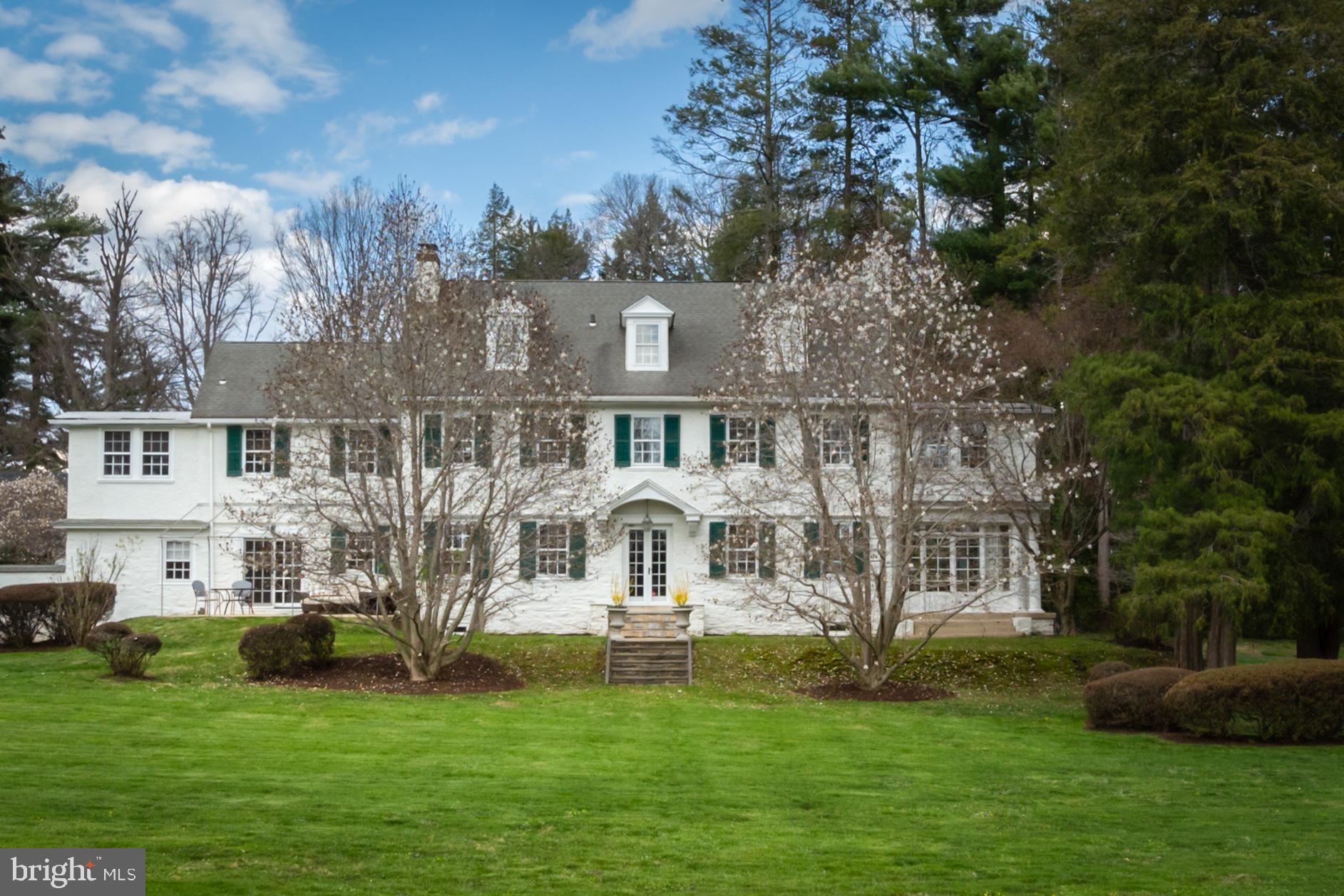 This gracious, classic 1920s colonial with impressive curb appeal is located on a corner lot in Haverford, overlooking Merion Golf Club. Positioned on nearly 1.5 acres, its time-honored craftsmanship includes substantial millwork, two fireplaces, high ceilings, original hardware, and hardwood floors, all within a well-built, lasting home. This gem, located close to Haverford College walking trails, excellent private and public schools, world-class shopping at Suburban Square and restaurants of Haverford Square, and so much more, is special indeed. The long driveway leads to the front entrance. The wide and welcoming reception foyer, with hardwood floors, leads to the formal living room on the left and dining room on the right. Each room has a fireplace, hardwood floors, large windows, and substantial millwork. From the living room, two sets of French doors lead to the sunporch, with an entire wall of windows and views of the golf course. A classic swinging door opens from the dining room into the eat-in kitchen. Updated and bright, the kitchen has wood cabinetry, some of which is glass-fronted, granite countertops, quality appliances, and hardwood floors. With recessed lighting and plentiful windows that let in natural light and beautiful views, this room is welcoming. Its large space includes an eating area for casual meals as well as an additional seating area. From the kitchen, a separate staircase leads to the second floor. A door leads to the patio with an awning and views of the golf course. There is also convenient access to the mudroom and powder room from the eating area. The mudroom leads to the driveway and garage, as well as the enclosed courtyard nestled between the house and garage. A beautiful, angled staircase leads to the generous landing with Palladium window and pretty shelf for decorative displays. The second floor has three bedrooms and three full bathrooms. The main bedroom has a spacious sunporch attached that serves as an office. This space, with 10+ windows, has beautiful views of the golf course. Both the bedroom and office have hardwood floors; the en-suite bath has a double vanity, tiled shower, and large windows. The second bedroom has a full bath that shares a door with the main bedroom, and the third bedroom has access to an additional bathroom. It also leads to another sunporch that overlooks the yard and golf course. A staircase leads to the third level, with two additional bedrooms and a hall bath with tub. Notably, on the back staircase landings, there is original, built-in storage. The first landing features a traditional linen closet, with wide shelves and drawers, while the second has pull-out drawers with original hardware. The private backyard, with its charming spaces, including a patio with awning, is lovely for entertaining and enjoying the outdoors. The beautiful yard is verdant and overlooks the golf course. This home is close to so much, including Haverford College walking trails and the nearby community recreation center with athletic fields and open space, as well as the shops at Suburban Square. There is easy access to the Regional Rail, for both quick commutes to Center City and the Amtrak to New York City. With easy access to the Blue Route, the airport is also accessible. Coupling elegance and beautiful surroundings with a matchless location, this home awaits you!