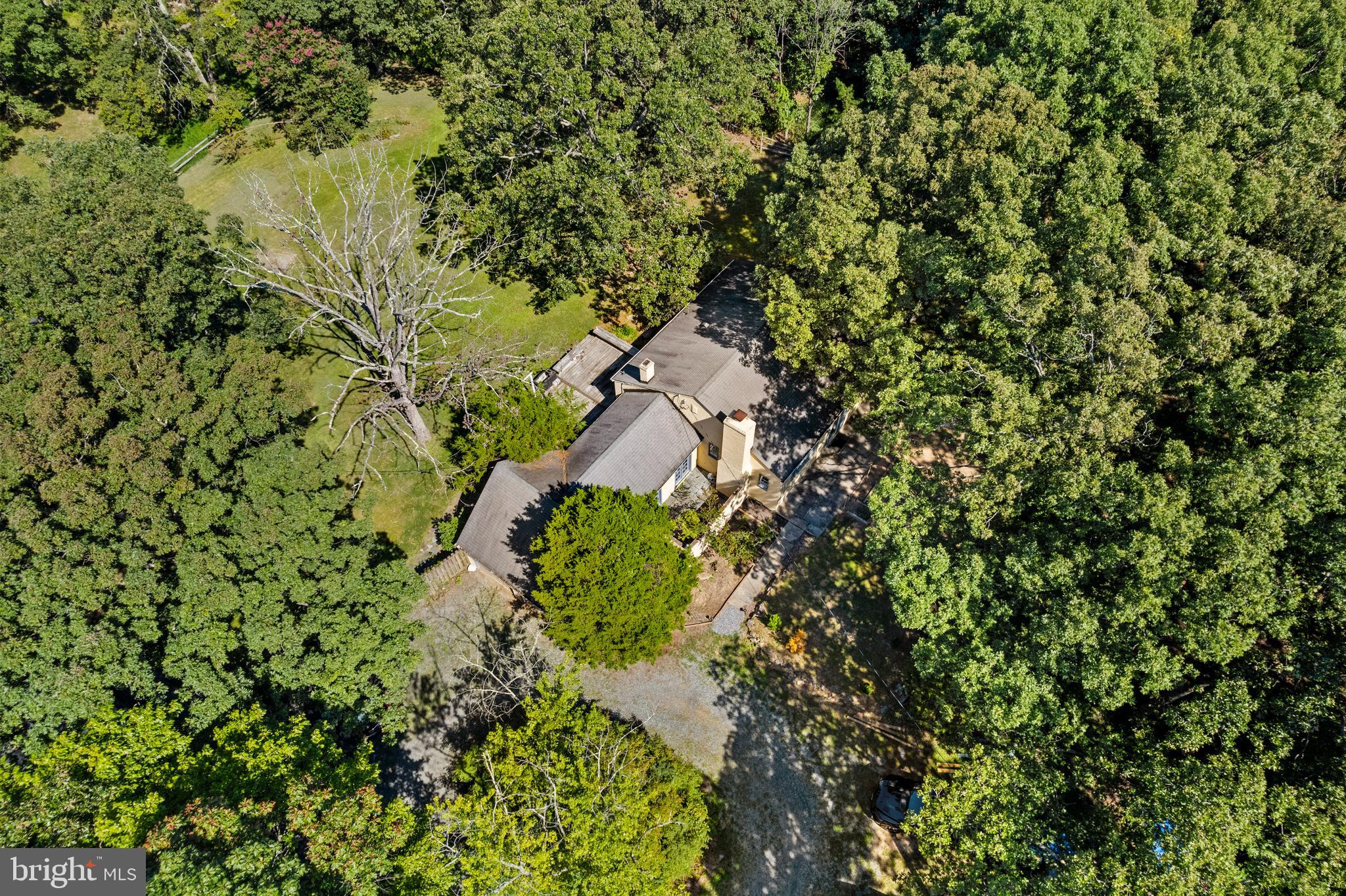 Exceptional 7.5 Acre Property in the Potomac Area! A rare and private retreat, this picturesque estate is set on expansive grounds with open green lawns bordered by mature trees and includes two separate homes in a serene natural setting. The true value of this property lies in the land, presenting a remarkable opportunity for future investment and vision. The main all-brick residence offers two bedrooms and one bath, with welcoming interiors that showcase rich hardwood floors, a timeless fireplace, and a bright sunroom with French doors and abundant windows that fill the home with natural light. Updates include an updated bathroom, new stove, and washer-dryer, adding comfort and convenience. The second detached home/guest house is approximately 700 square feet and provides three bedrooms and one bath plus a brand-new HVAC system, making it ideal for multi-generational living, rental income, or a private studio/office. Additional highlights include a two-car garage, a circular driveway with 8 parking spaces, mature landscaping, and direct adjacency to the Serpentine Barrens Conservation Park with more than 150 acres of protected parkland. Just minutes from local wineries, Glenstone Museum, Potomac Village, and commuter routes, this estate offers both privacy and convenience. The land itself is the rare opportunity with 7.5 acres in the Pristine Potomac area. A rare investment opportunity whether envisioned as a private sanctuary, multi-generational retreat, or income-producing property this estate delivers acreage, versatility, and lifestyle appeal in one of Montgomery County’s most desirable areas. This Property offered in As -is condition. The homes have been thoughtfully updated and are income producing.