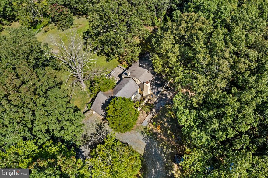 Exceptional 7.5 Acre Property in the Potomac Area! A rare and private retreat, this picturesque estate is set on expansive grounds with open green lawns bordered by mature trees and includes two separate homes in a serene natural setting.  The true value of this property lies in the land, presenting a remarkable opportunity for future investment and vision. The main all-brick residence offers two bedrooms and one bath, with welcoming interiors that showcase rich hardwood floors, a timeless fireplace, and a bright sunroom with French doors and abundant windows that fill the home with natural light. Updates include an updated bathroom, new stove, and washer-dryer, adding comfort and convenience. The second detached home/guest house is approximately 700 square feet and provides three bedrooms and one bath plus a brand-new HVAC system, making it ideal for multi-generational living, rental income, or a private studio/office. Additional highlights include a two-car garage, a circular driveway with 8 parking spaces, mature landscaping, and direct adjacency to the Serpentine Barrens Conservation Park with more than 150 acres of protected parkland. Just minutes from local wineries, Glenstone Museum, Potomac Village, and commuter routes, this estate offers both privacy and convenience. The land itself is the rare opportunity with 7.5 acres in the Pristine Potomac area.  A rare investment opportunity whether envisioned as a private sanctuary, multi-generational retreat, or income-producing property this estate delivers acreage, versatility, and lifestyle appeal in one of Montgomery County’s most desirable areas. This Property offered in As -is condition. The homes have been thoughtfully updated and are income producing.