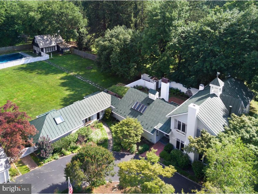 Highly styled and newly updated, this 100+ year old 5 Bedroom 4/2 bath European carriage home dazzles with high ceilings, natural light and a connected open-plan on a flat 1.1 acre parcel.  Offering superior amenities and privacy from a long drive, evergreen border and deep rear yard. A classic pool and unparalleled four season vaulted ceiling Pool House with rustic walk-in wood burning fireplace and half bath offers year-round entertaining and spectacular retreat space. The home itself, enhanced by cottage style gardens, has been considered and executed to the last detail. A fresh, sophisticated interior with just renovated two story sparkling white Kitchen features an oversized Quartzite seated island which flows to the Great Room and breakfast area. Additional appeal comes from original elements such as wide plank heart-pine floors, industrial iron trusses and views of fountains and pergolas with climbing centennial wisteria vines.  A wood burning fireplace in the adjacent Great Room is flanked by two sets of French doors leading to a romantic private walled terrace and beyond to a deluxe Master Suite on this garden level. Brightened by large windows, the separate Dining Room enjoys southern and western exposures while well positioned French doors open to outdoor dining allowing for seamless flow and gracious entertaining. A two-room guest suite located in the opposite corner of the home from the master suite, has a separate front and rear entrance and offers exceptional family or long stay guest space. Three additional Bedrooms, one with step down Study, and two full baths are located on the second level. Chic, fresh and so very livable.