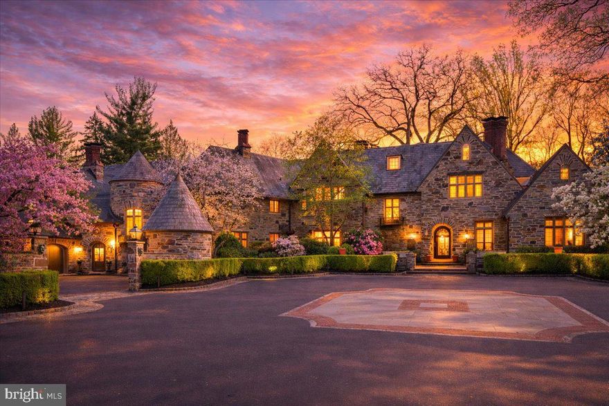 Privately tucked behind gated stone piers in Gladwyne, “Wooded Hill” unfolds across nearly seven acres of lush, mature grounds designed for both quiet seclusion and outdoor enjoyment. Expansive lawns, formal gardens, winding stone paths, and a pool with pavilion create a setting that feels more like a private retreat than a traditional residence. A dedicated golf green with multiple tee boxes and a series of terraces further extend the outdoor living experience.

At the center of the property sits a 16,410-square-foot residence that blends historic character with extensive modern upgrades. Natural light pours in from every angle, highlighting detailed craftsmanship such as custom millwork, decorative iron accents, intricate ceiling designs, and seven fireplaces. French doors throughout the home open to the surrounding landscape, reinforcing the connection between indoor and outdoor spaces.

The home is equally suited for large-scale entertaining and everyday living. Gathering spaces include formal living and dining rooms, a sunroom, a billiards room, and multiple family rooms, while two private offices provide flexibility for work or study. The kitchen, positioned as a central hub, is paired with a bright breakfast area for casual dining.

A private primary wing offers a retreat within the home, complete with dual spa-like baths, a sitting area, and a balcony library overlooking a dramatic two-story family room. Additional bedroom suites—each with walk-in closets and private baths—are complemented by a second-floor library. Altogether, the property accommodates eight bedrooms, including a fully independent two-bedroom apartment ideal for extended stays or live-in support.

The lower level expands the home’s recreational offerings with a theater featuring tiered seating, a fitness room, a custom bar, and direct access to the outdoor entertaining areas.

A separate guest house, thoughtfully renovated with a more contemporary aesthetic, provides two additional bedrooms and a sense of privacy for visitors, accessible through a charming stone courtyard.

Modern infrastructure supports the estate’s scale and convenience, including a whole-house generator and an integrated smart home system controlling lighting, security, audio, and pool functions.

Despite its secluded setting, the property is just minutes from local village amenities, King of Prussia, Center City Philadelphia, and major transportation routes—offering both privacy and accessibility in one of the Main Line’s most desirable locations