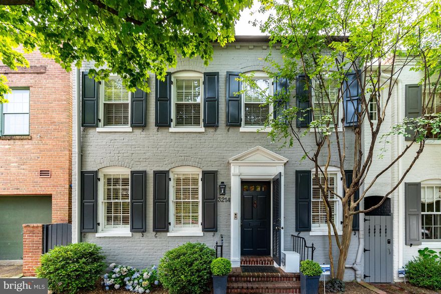 Located on a quiet block in the East Village, 3214 Reservoir Road is perfectly situated near the fine dining and shopping of Georgetown, as well as grocery stores, coffee shops and green spaces. This semi-detached, all brick townhouse was built over a century ago, but has been exceedingly well-cared for and the current owners undertook their recent renovation to showcase the property’s original features and refinement while rethinking details to upgrade and modernize the house.
 
Enter the house via the main level center hall which serves as a hub to most of this level. To the right of the center hall is a newly added laundry/mud room, a new powder room, and a stairwell leading to both the upper and lower floors. To the left of the center hall is the updated kitchen with substantial custom cabinetry, high-end appliances such as a Wolf gas oven and a Fisher & Paykel dishwasher. The kitchen opens to a large dining room, and further onto a separate south-facing sitting room, with access to the garden. At the end of the center hall, there is a nicely hidden wet-bar and large living room with wood-burning fireplace and direct garden access. Adding to the general nice layout of the main level, the living room and sitting room are connected, creating a circular flow.
 
The upper floor is as meticulous and inviting as the main level. Again, there is a spacious and light filled hall that serves as the hub for this level. This floor features three bedrooms and three bathrooms, two being en suite. The primary bedroom is spacious and includes an adjoining side-room with a southern exposure and garden views. It is currently used as an office, but could be a dressing room, fitness room, or any combination of these. Three skylights provide light throughout the primary bedroom and upper floor landing. Two more bedrooms both with ample closets, a hall bath, and a linen closet complete the level. Each of the other bedrooms are special, one is quite large and the other is very cute.
 
The lower level has been smartly re-thought by the current owner and is now a very useable space. While currently set up as a children’s playroom, the area makes an excellent family room. The lower level also features a separate storage area. 
 
The exterior of the house features a secure, private pathway along the house from front to back for access to the garden. The garden is private and an ideal size for intimate gatherings or family entertaining and relaxing. The smart floor plan of the house allows for garden access from the living room, the sitting room, and the private walkway.

The current owners have upgraded many elements including the following additions: 
•