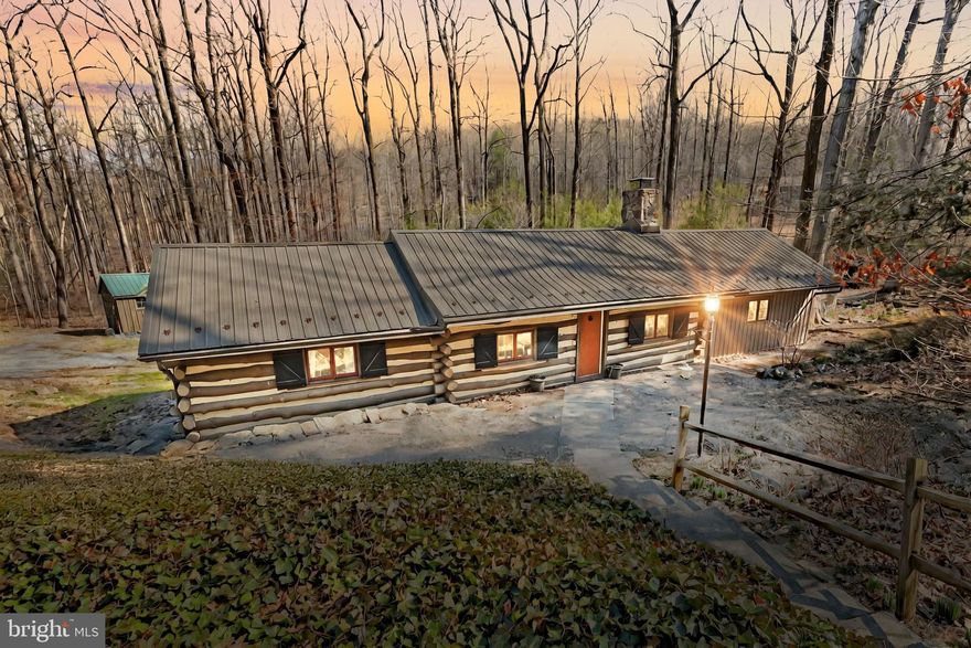 Escape to your own private retreat in the woods with this rare and charming 2-bedroom, 1-bath log cabin on 2.33 acres in Spring Grove.**NEW $10,000   Price Improvement  ** Seller is also offering $5000. towards helping the new owner make it their own! **Highly Motivated Seller!
Whether you're looking for a full-time home, a weekend getaway, or an Airbnb opportunity, this property delivers the perfect mix of rustic charm and modern comfort.

Inside, vaulted ceilings make the space feel open and airy, while the floor-to-ceiling stone mantel and wood-burning stove add warmth and character. The layout is simple yet inviting, designed for cozy nights by the fire and lazy mornings with a cup of coffee. Step outside onto the massive covered deck that spans the length of the home, offering the ideal spot to get lost in the peaceful surroundings.

But the magic of this property doesn’t stop at the cabin. Outside, you’ll find an outdoor custom stone stove/oven, a barn-style shed with a carport, an additional electric-powered shed, a wood shed, and even a quirky decorative outhouse that adds to the character. A custom-built stone-bottom pond brings even more charm, creating a picture-perfect setting for relaxing and unwinding.

Thinking about homesteading? There’s already a fenced-in area with wide gates, big enough for a horse or small livestock. And yes...that does mean you can have livestock! You can have up to 2 horses on the property and up to 23 chickens! Of course there are plenty of other livestock you can keep too!  Need space for vehicles, equipment, or guests? The driveway can handle 10+ cars with ease and it's even a pull through making dealing with trailers, RV's and everything in between a breeze! 

Located just minutes from Lake Pahagaco and Lincoln Speedway, this property offers both seclusion and convenience. Whether you’re into fishing, hiking, or catching the next big race, adventure is never far away.
This is more than just a house—it’s a lifestyle. A place to disconnect, breathe deep, and enjoy nature at its finest.