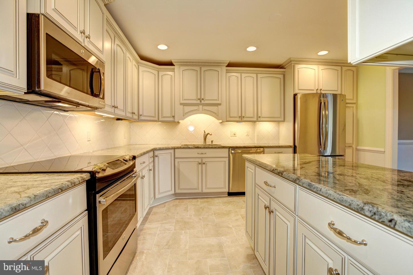 Smashing renovation! Lovely corner unit at rear of building, light-filled, views of woods and stream! 1,912 square feet, upgraded in every aspect. TS kitchen with custom cabinetry, all new SS appliances, breakfast bar, exquisite marble countertops. New bamboo flooring. 2 BRs plus Den w fireplace & built-ins. 3 renovated FBAs! 2 garage spots. Walk to Starbucks, public transport, grocery store, more