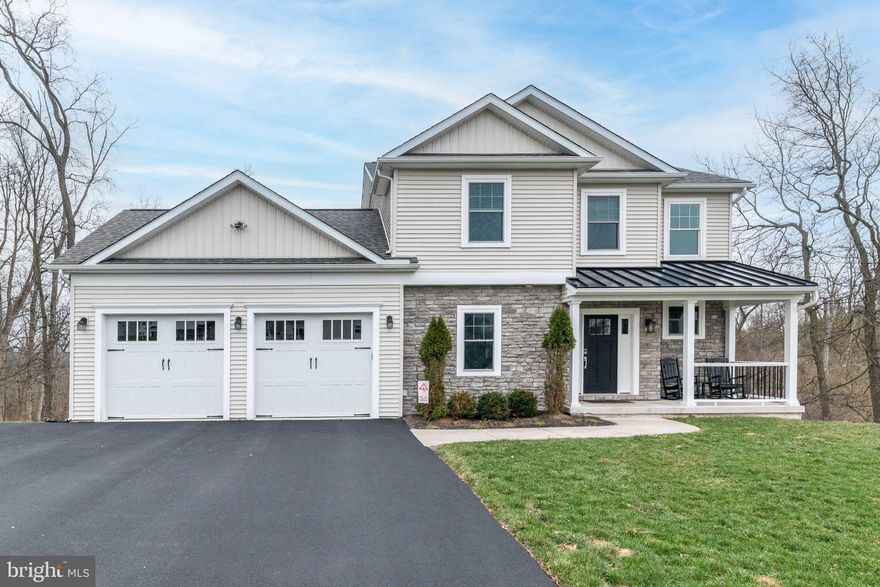 Welcome to a rare 422 gem. This is the last home built in High Meadow, just 6 years young and thoughtfully upgraded throughout. A welcoming front porch with a metal roof and stone accents sets the tone. Inside, the bright open layout showcases hardwood floors, an iron spoked staircase, and a sun filled great room with beautiful views and a central fireplace. The space flows seamlessly into the dining area with slider access to a poly deck. From here, a spiral staircase leads to a second, larger lower deck, an ideal setup for entertaining or relaxing outdoors. The kitchen features granite countertops, an extended breakfast bar, glass tile backsplash, apron sink, and recessed lighting in every room. A powder room, laundry room, and garage access complete the main floor. Upstairs, more hardwood floors lead to three bedrooms. The front bedroom includes a walk in closet, partial cathedral ceiling, and full-size access to a large floored storage area over the garage. A second bedroom and a fully tiled hall bath sit nearby. At the end of the hall, the primary suite impresses with a full cathedral ceiling, stunning windows, walk in closet with attic access, double marble vanity, and a large shower with half wall. The daylight basement is a standout feature, so bright you rarely need lights. With 11–12 ft ceilings, sliders to the lower deck, and multiple windows, it’s an incredible bonus space for recreation, hobbies, or relaxation. Two additional rooms house utilities. A valuable compliment to the above garage storage and upstairs attic is the additional fully concrete storage room beneath the garage. It’s accessible from the basement and utility area, with convenient double door access from outside, ideal for tools, equipment, or seasonal items. Nestled in the heart of Douglassville, this home offers the perfect blend of convenience and community. Residents enjoy easy access to major routes, local shopping, parks, and the natural beauty Berks County is known for.
