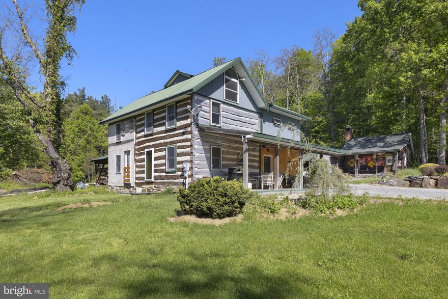Situated on 20+ picturesque acres in Franklin Township, this unique property features an 1860 log home thoughtfully expanded with a 1999 addition, blending historic charm with modern comfort. Offering 3 bedrooms and 1 full bath with convenient main-floor laundry, the home is filled with character including exposed log walls, open beams, and an oversized kitchen designed for gathering and everyday living. A potential large primary bedroom provides additional flexibility for future expansion or customization.
Comfort is enhanced with radiant heat, mini splits, and an outdoor wood furnace with dual-fuel oil backup for efficient year-round heating. Step through the sliding doors to a rear patio wired for a hot tub and large gazebo, perfect for relaxing and enjoying the peaceful surroundings. The covered front porch with ceiling fans create inviting outdoor spaces to unwind.
The property also includes a 49x24 pole barn with electric and attached carport, ideal for storage, equipment, hobbies, or workshop use. An additional outbuilding offers excellent potential for a private office, studio, or remote-working space. With open acreage, privacy, and endless possibilities, this property is perfect for those seeking country living with room to expand.