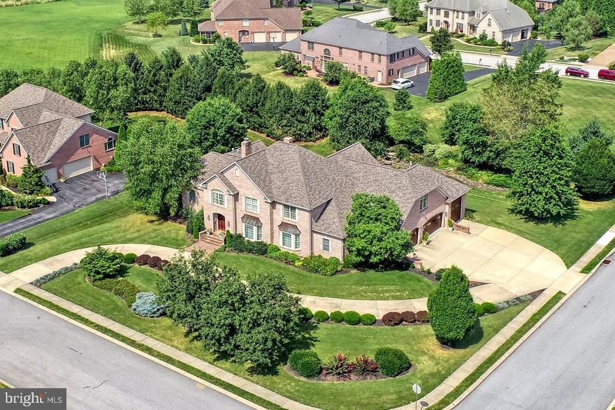 Sitting on one of the premier lots in Brittany, York, PA with over 6.000 sq ft of living area, exquisite finishes, and unparalleled architectural detail this amazing home will fulfill your every desire and welcome you.  This home offers stunning presentation inside and outside. The main level boasts a formal Living Room and formal Dining Room showcasing Brazilian Cherry hardwood floors, custom millwork and expansive windows.  The Gourmet Cooks Kitchen with oversized dining area, offers granite countertops, top-tier stainless steel appliances, two large oversized islands and opens to the Great Room with gas fireplace, built-ins and soaring cathedral ceiling.  The Great Room and Kitchen with walls of windows overlook  and open to the custom two story Brick covered outdoor porch fully equipped with Fireplace, Ceiling Fan and built-in TV hookup for your complete entertaining desires.  The 1st floor Master Suite with 2 walk-in closets, boasts an oversized Full Bath with jacuzzi tub and walk-in shower showcasing a custom artistic glass shower wall.   The Main Level Annex is home to a private office, Laundry Room and Full Bath.  This is a possible Nanny Suite or perfect Guest Suite.  The expansive Upper Level begins with a Loft area for extra study space, play space, or office space.  There are 4 large bedrooms, 2 bedrooms share a jack-n-jill Full Bath, 2 bedrooms share a large Full Bath.  There is a 2nd floor Laundry.  Dual staircases to the upper level make all the rooms easily accessible.  The Lower Level is amazing.  The walk-out Family Room/Game Room area with gas fireplace is expansive.   Enjoy the Media Room/Exercise Room complete with full bath.  This home is equipped with 4 garages.  One garage is custom designed to park and store an RV.  The 3 car garage area has heated floors and custom built-ins, perfect for the garage enthusiast.  The gardens of the home are beautifully landscaped.  The rear covered brick porch overlooks the pond with waterfalls.  Stunning and private, this home is perfect for many styles of living.  Located minutes to Rt. 30, I83, hospitals schools and shopping.  The perfect location for anyone who works in North York, South York and beyond.  This home is a must see.
