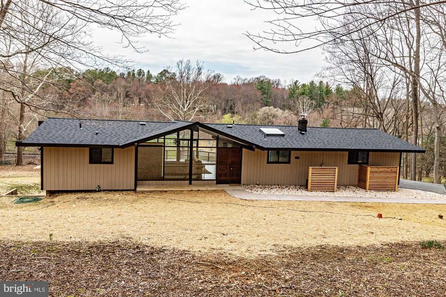 Tucked away on the Yorklyn side of Hockessin, in the heart of the Auburn Valley nature area along the scenic Red Clay Valley Byway, this one-of-a-kind Mid Century Modern/Western Contemporary hillside ranch offers a rare blend of architectural character and modern updates. Set on just over an acre, the home has undergone a complete transformation with a thoughtful emphasis on period-inspired finishes that honor its design roots while delivering today’s lifestyle. 
Inside, soaring ceilings and walls of floor-to-ceiling glass create a striking first impression, filling the home with natural light and seamlessly connecting the interior to its picturesque surroundings. The open floor plan is ideal for both everyday living and entertaining, with clean lines and curated finishes throughout. 
The main level features a desirable first-floor primary suite complete with a custom walk-in closet and direct access to the rear deck—perfect for enjoying peaceful morning coffee or evening sunsets overlooking the natural landscape. 
The walk-out lower level expands the living space with a spacious second living area, full bathroom, and three additional bedrooms—ideal for guests, family, or flexible work-from-home needs. 
A truly unique offering in one of Northern Delaware’s most scenic settings, this home delivers style, privacy, and a connection to nature that is rarely found.
